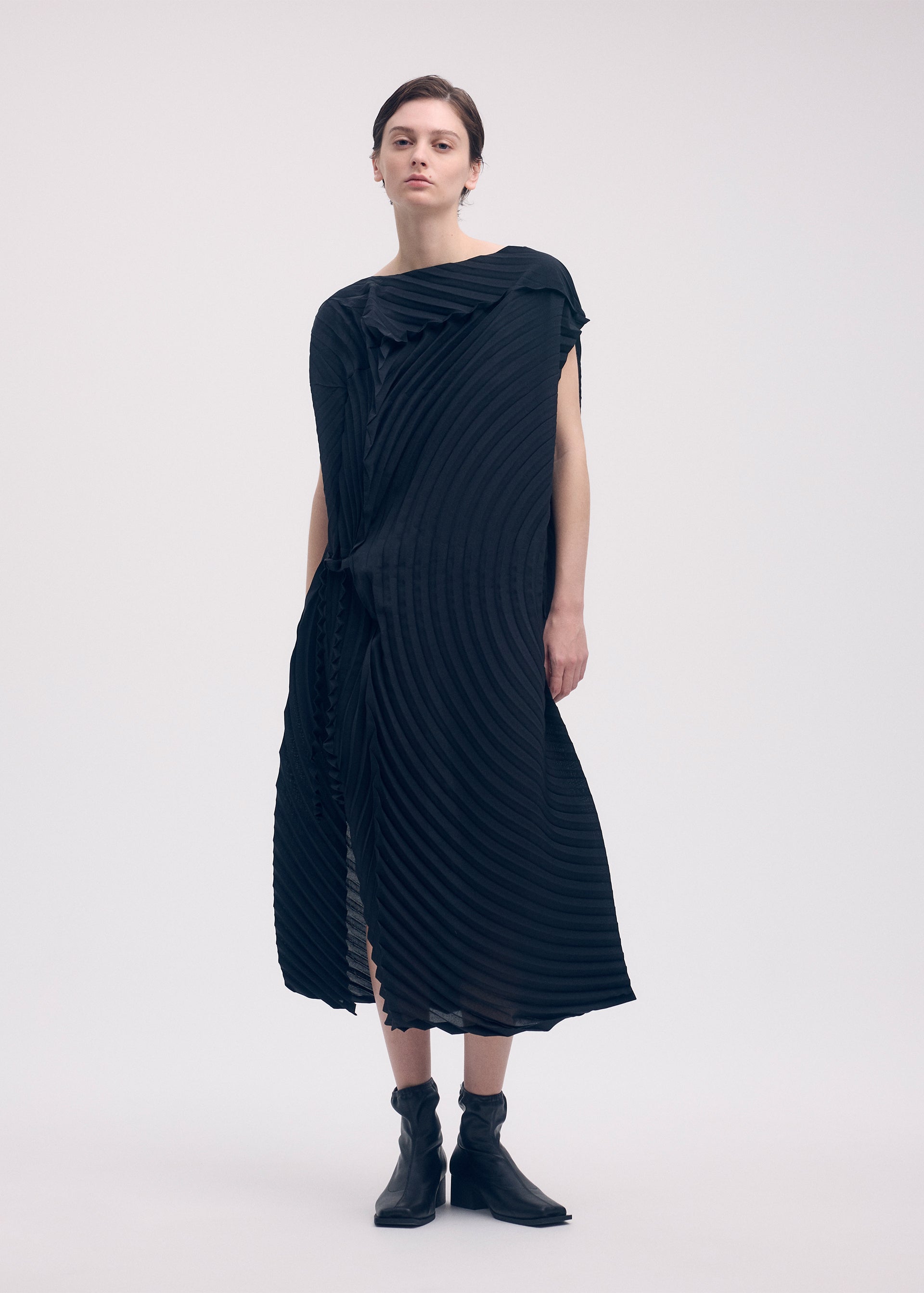 A model wears the ISSEY MIYAKE PAPER BAG PLEATS dress.