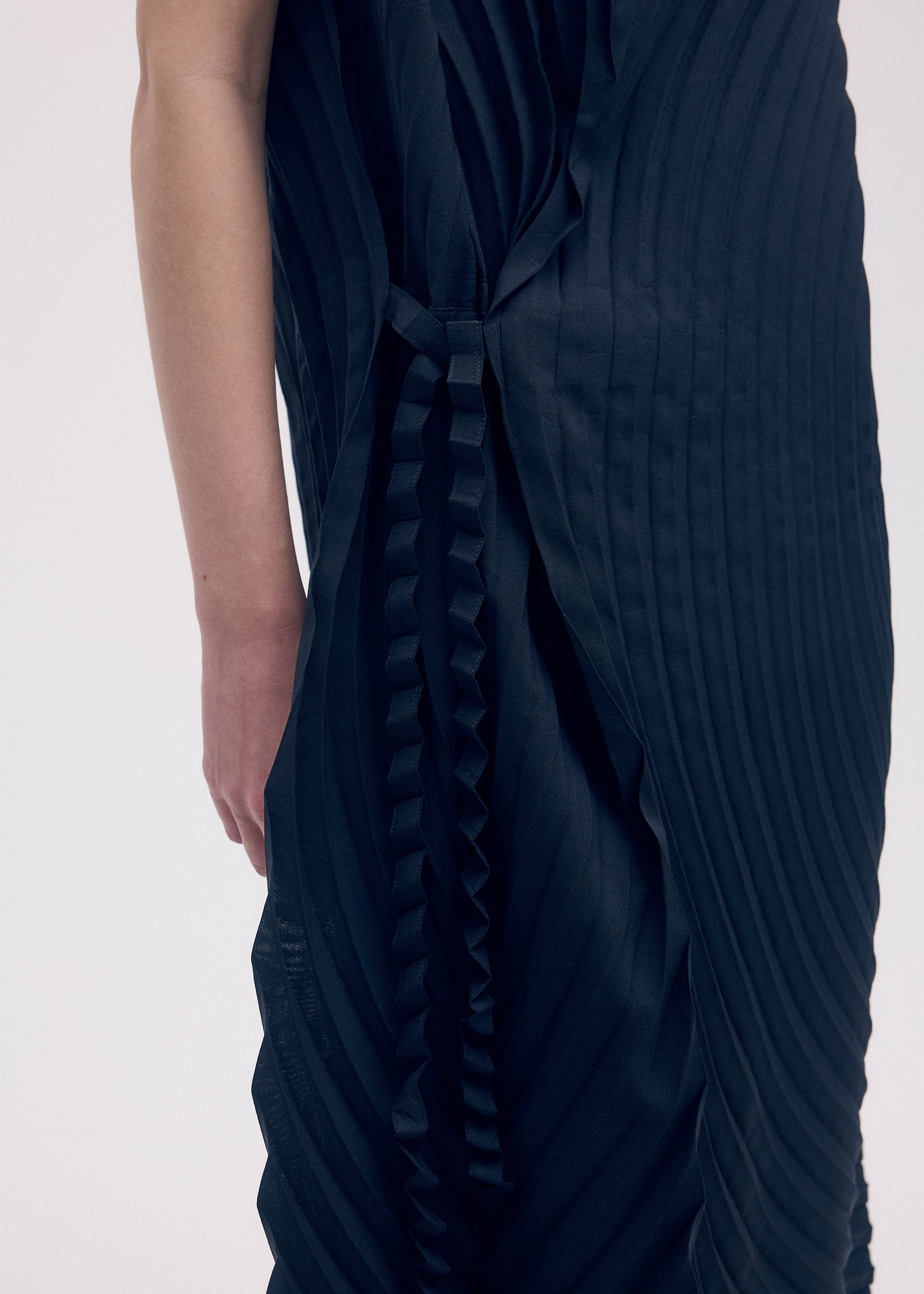 A model wears the ISSEY MIYAKE PAPER BAG PLEATS dress.