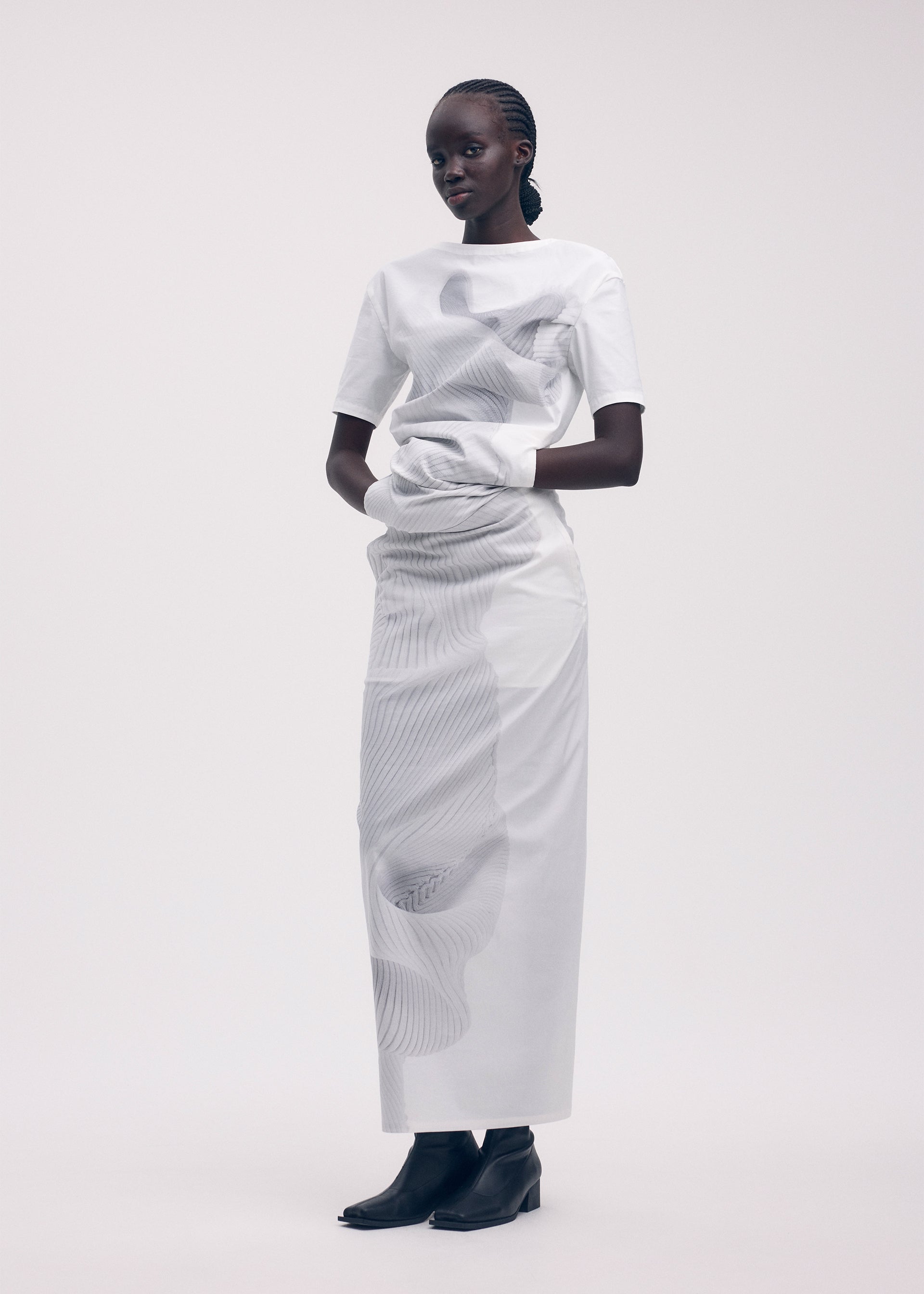 A model wears the ISSEY MIYAKE KNIT (AS REPRESENTED) shirt.