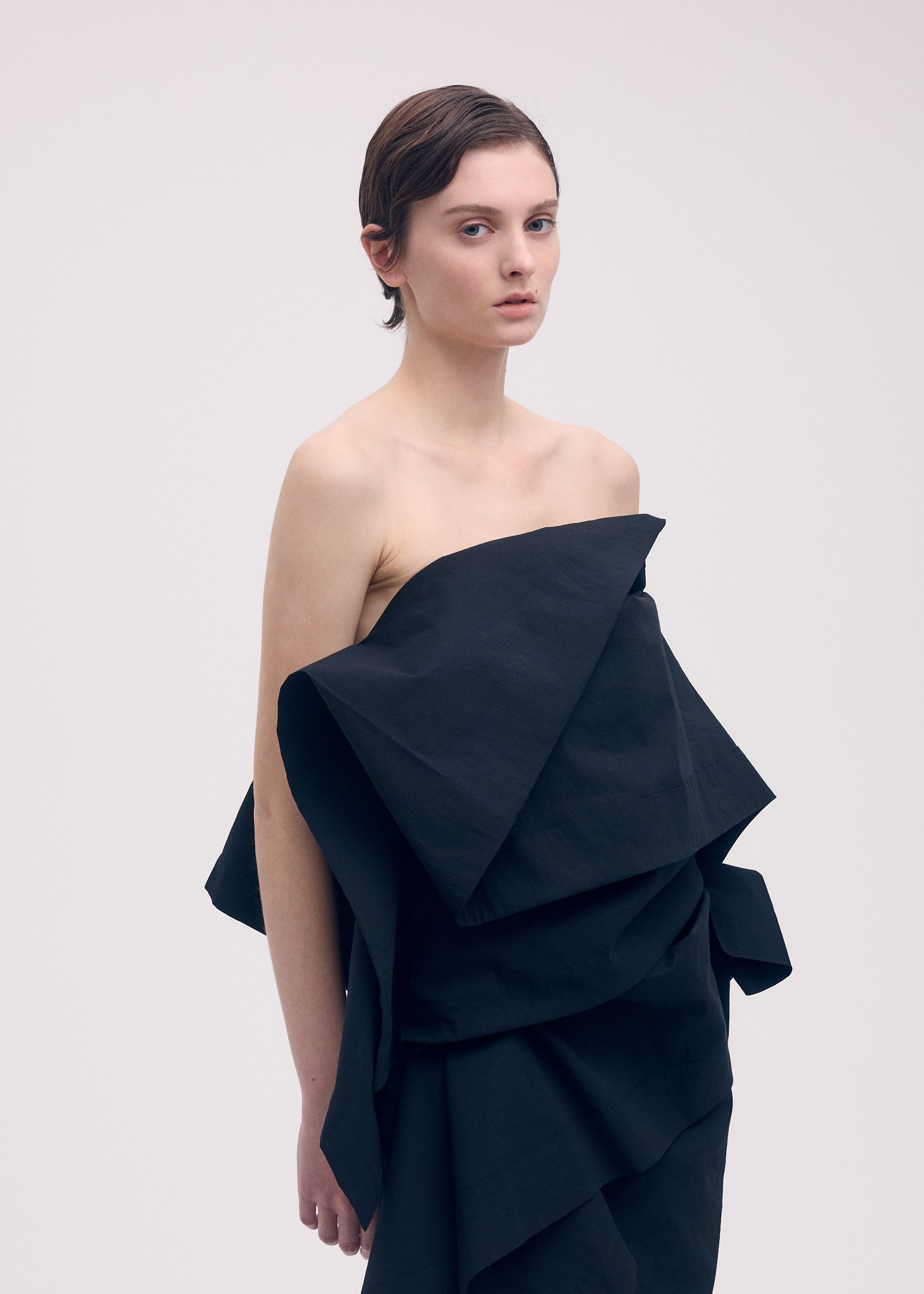 A model wears the ISSEY MIYAKE COLLAPSING SCULPTURE shirt.