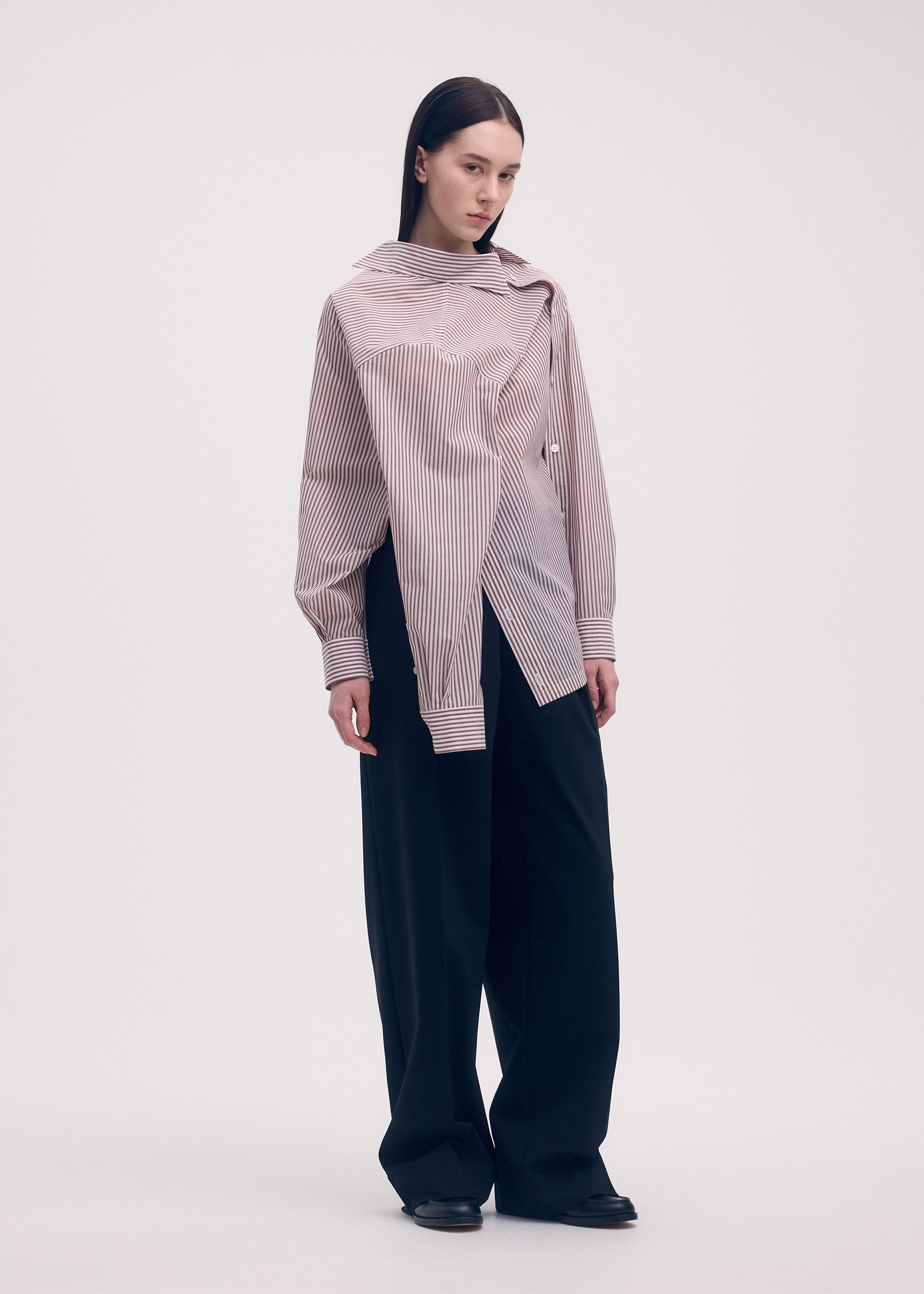 A model wears the ISSEY MIYAKE ODD SHIRT (STRIPES) shirt.