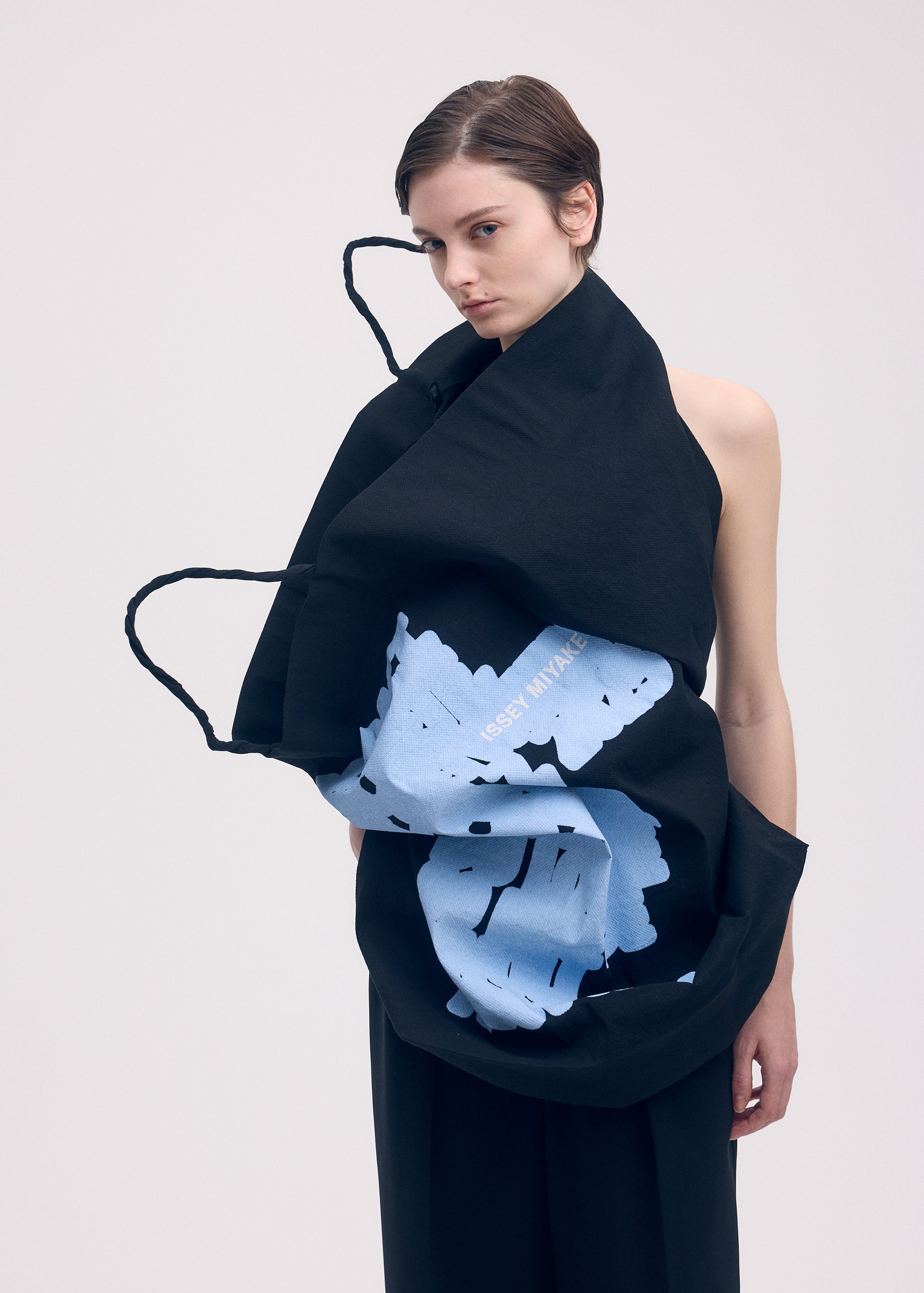 A model wears the ISSEY MIYAKE PAPER BAG (POSTER) shirt.