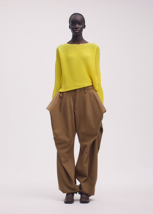 A model wears the ISSEY MIYAKE SHIFTED MISTY PLEATS clothing.