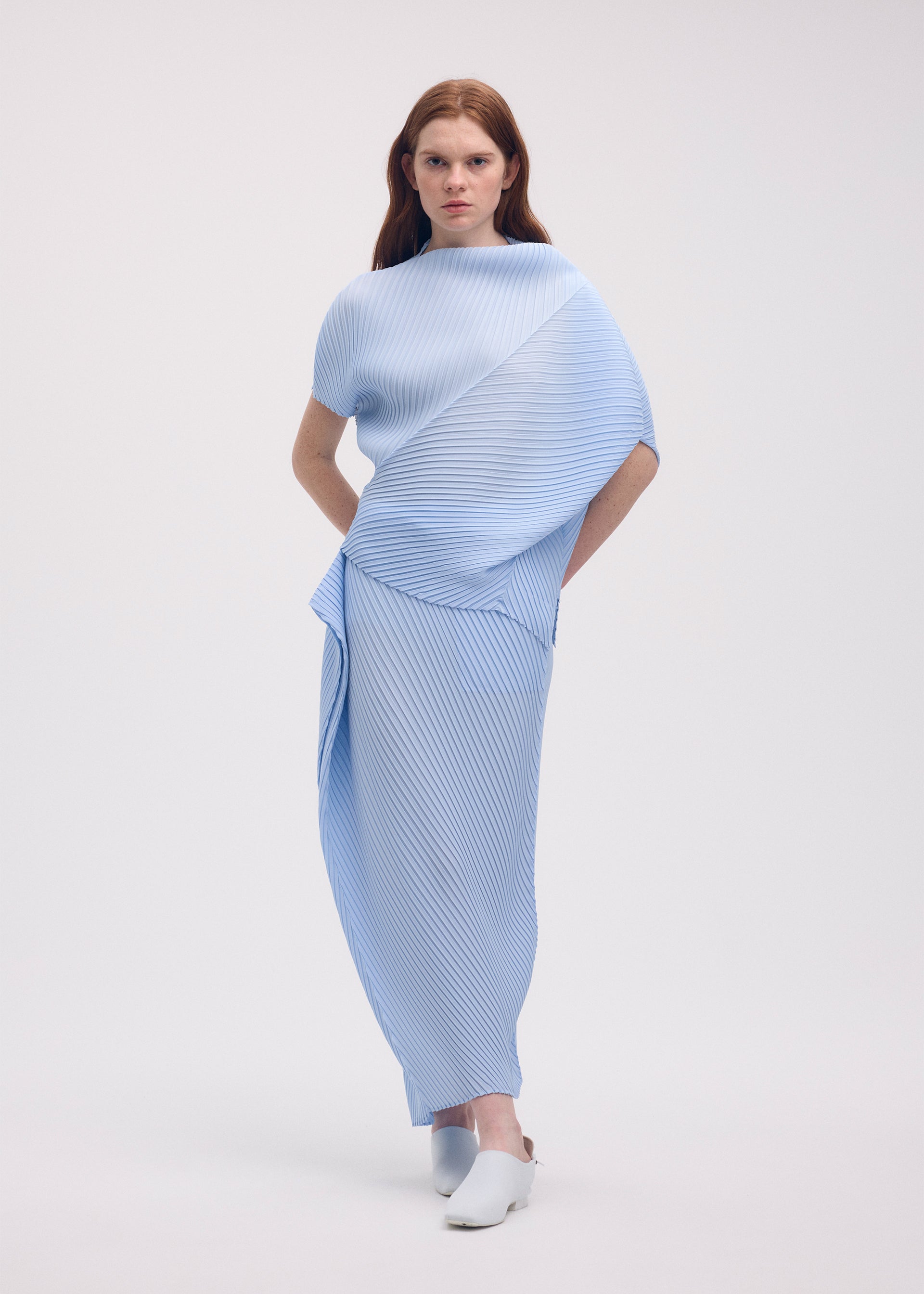 A model wears the ISSEY MIYAKE SOFT FOLD PLEATS shirt.