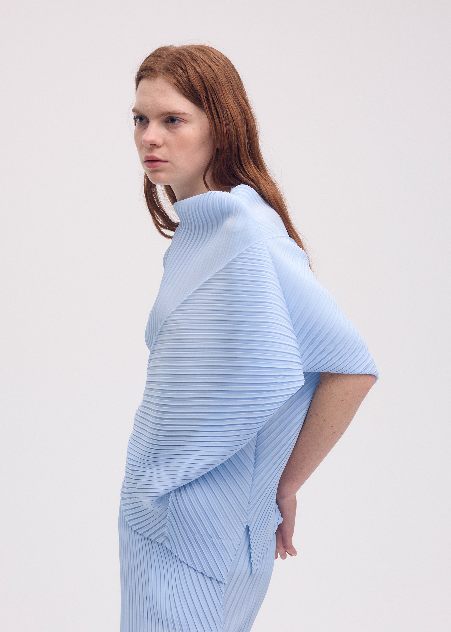 A model wears the ISSEY MIYAKE SOFT FOLD PLEATS shirt.
