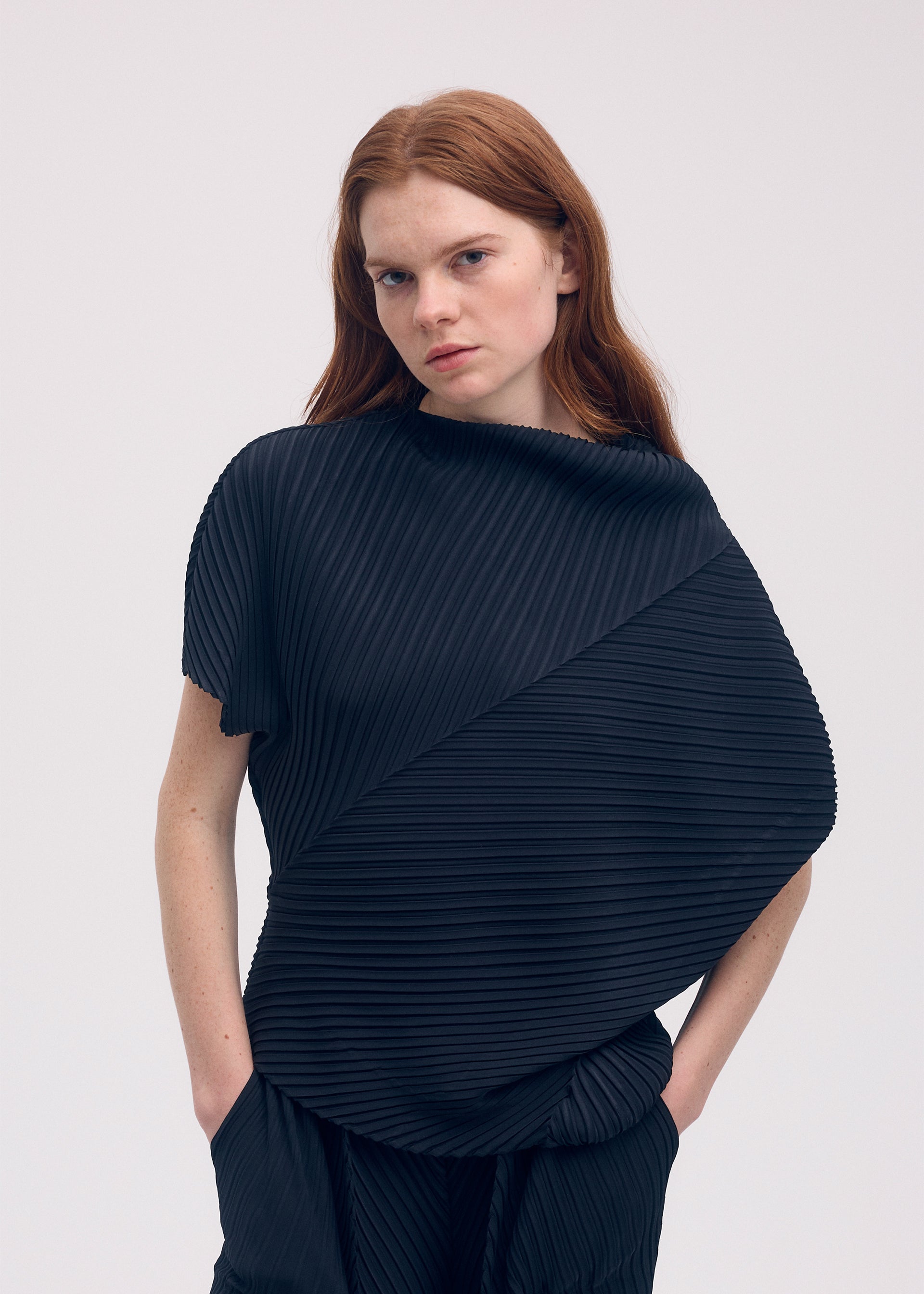 A model wears the ISSEY MIYAKE SOFT FOLD PLEATS shirt.