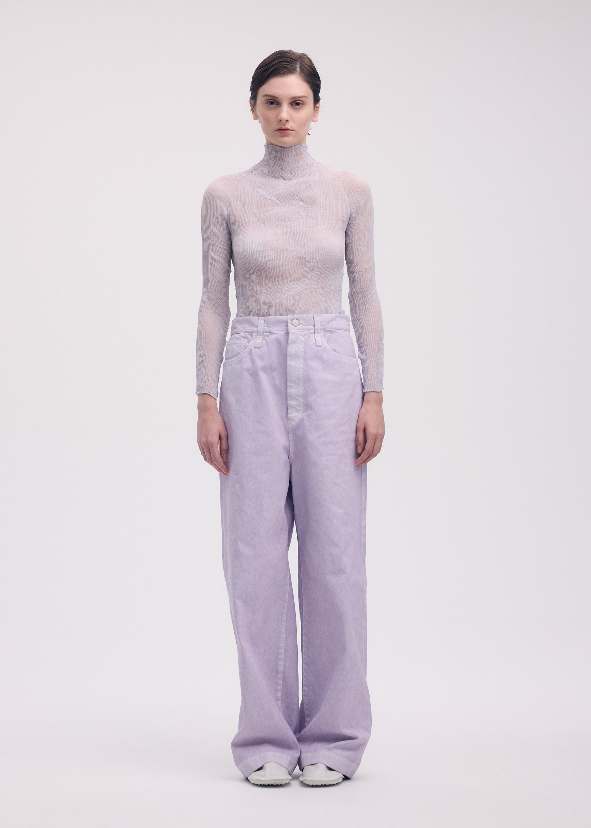 A model wears the ISSEY MIYAKE CHIFFON TWIST 1 top.