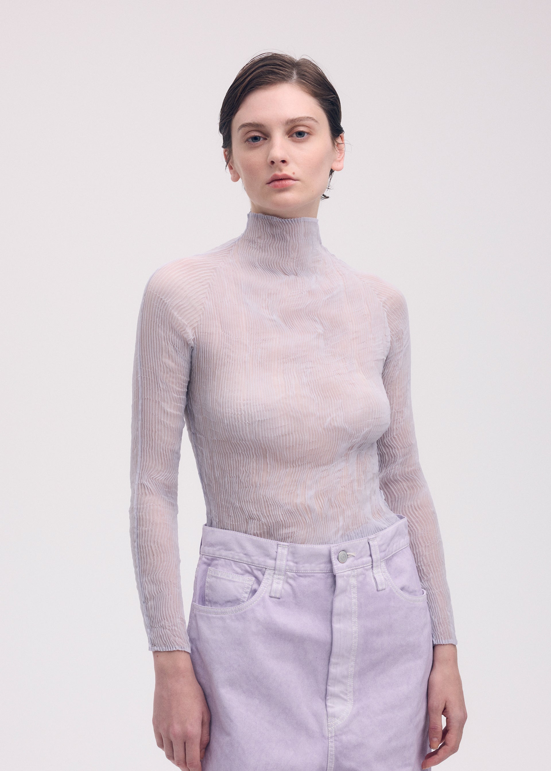 A model wears the ISSEY MIYAKE CHIFFON TWIST 1 top.