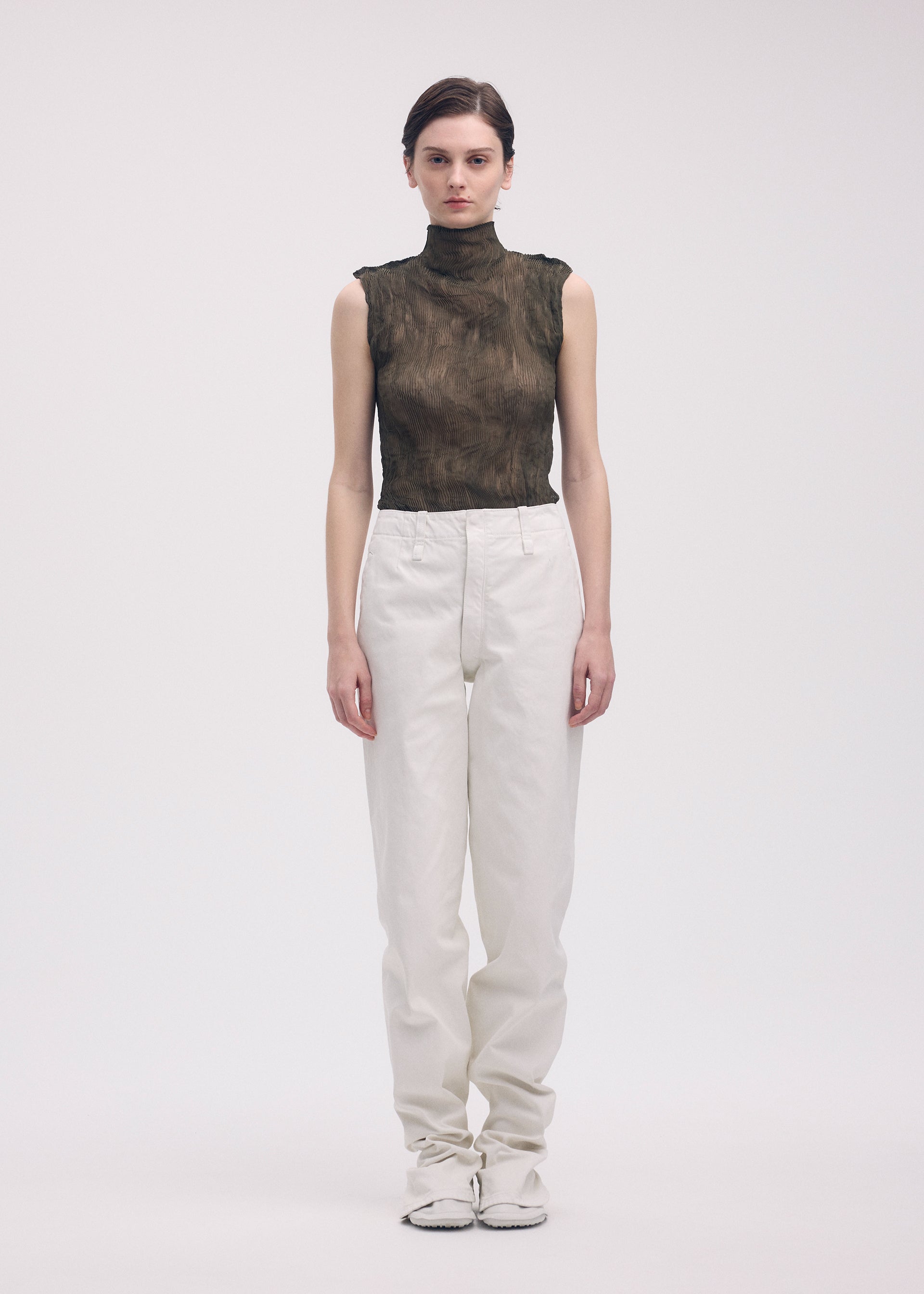 A model wears the ISSEY MIYAKE CHIFFON TWIST 1 top.