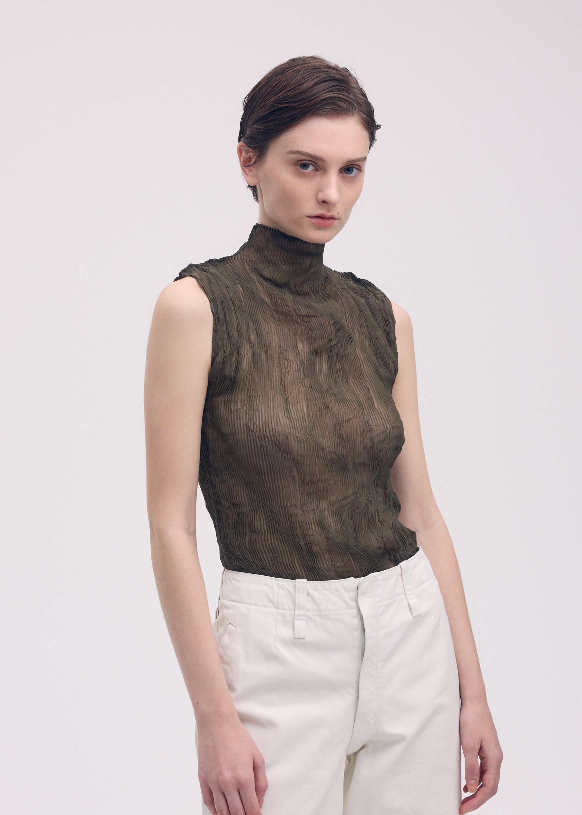 A model wears the ISSEY MIYAKE CHIFFON TWIST 1 top.
