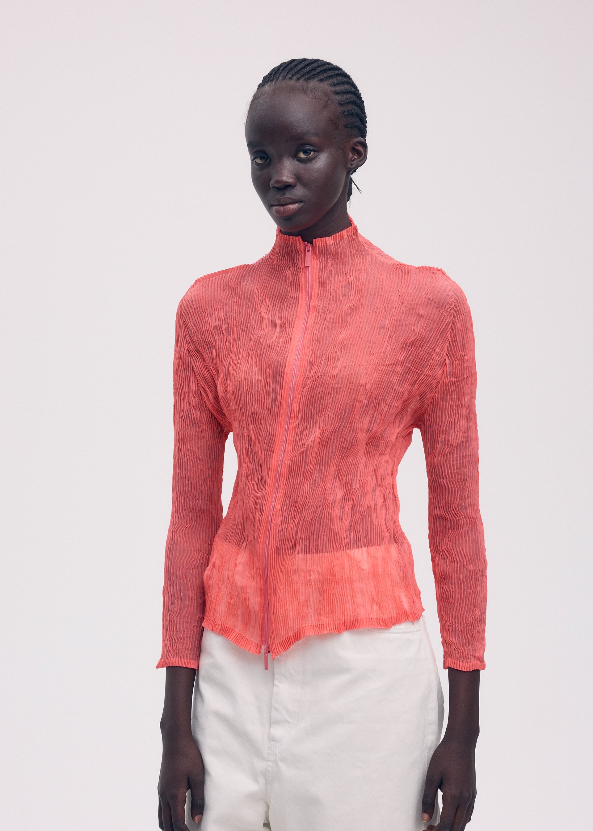 A model wears the ISSEY MIYAKE CHIFFON TWIST 1 top.