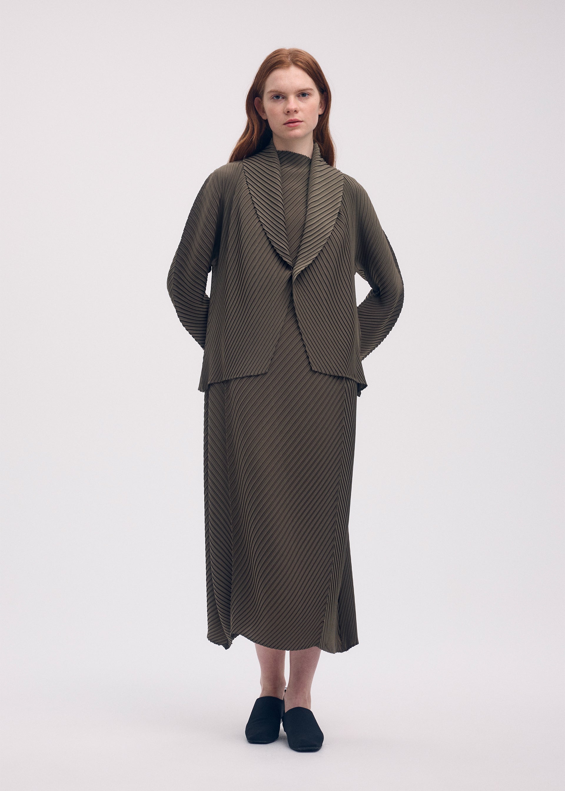 A model wears the ISSEY MIYAKE SOFT FOLD PLEATS cardigan.