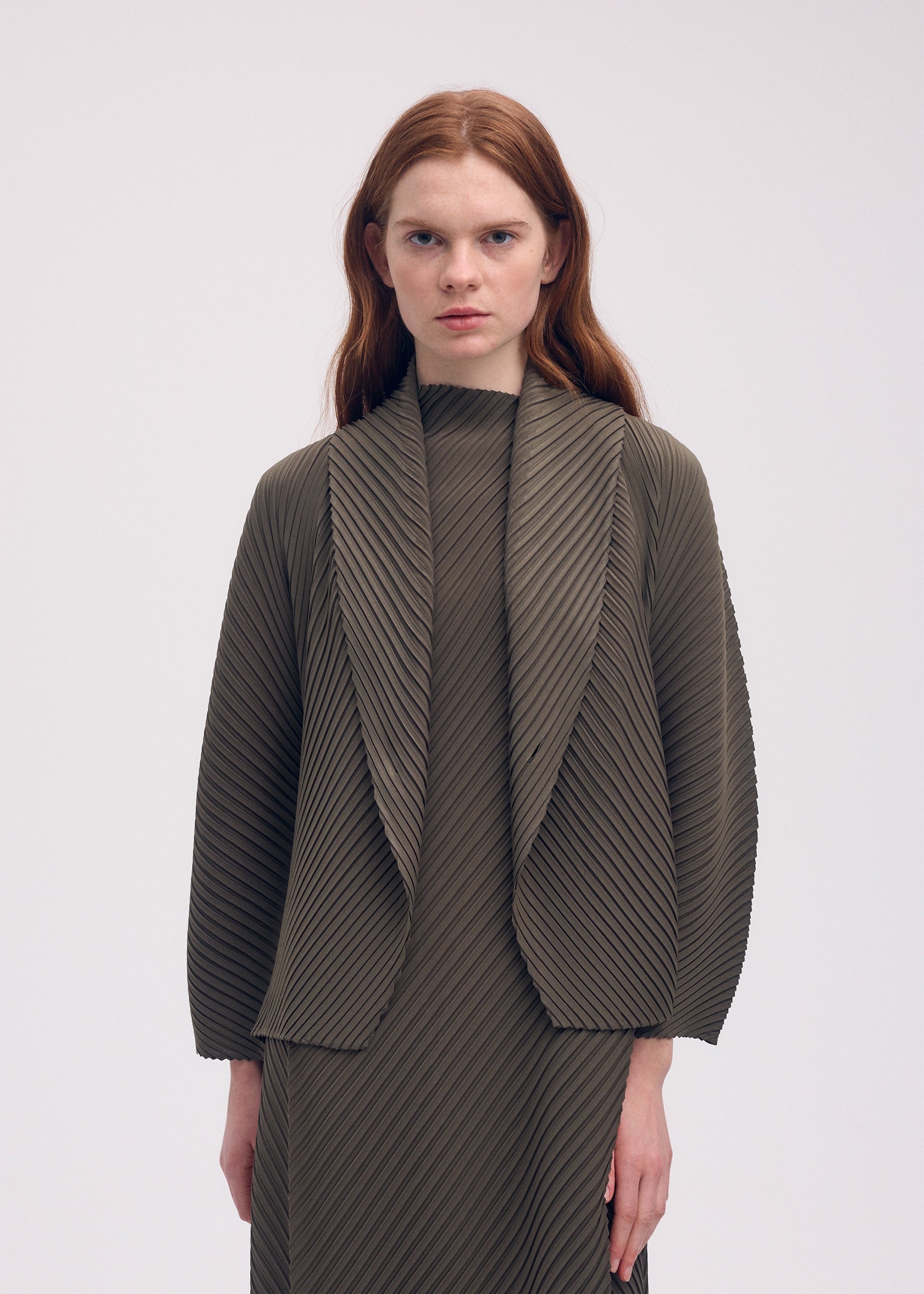 A model wears the ISSEY MIYAKE SOFT FOLD PLEATS cardigan.