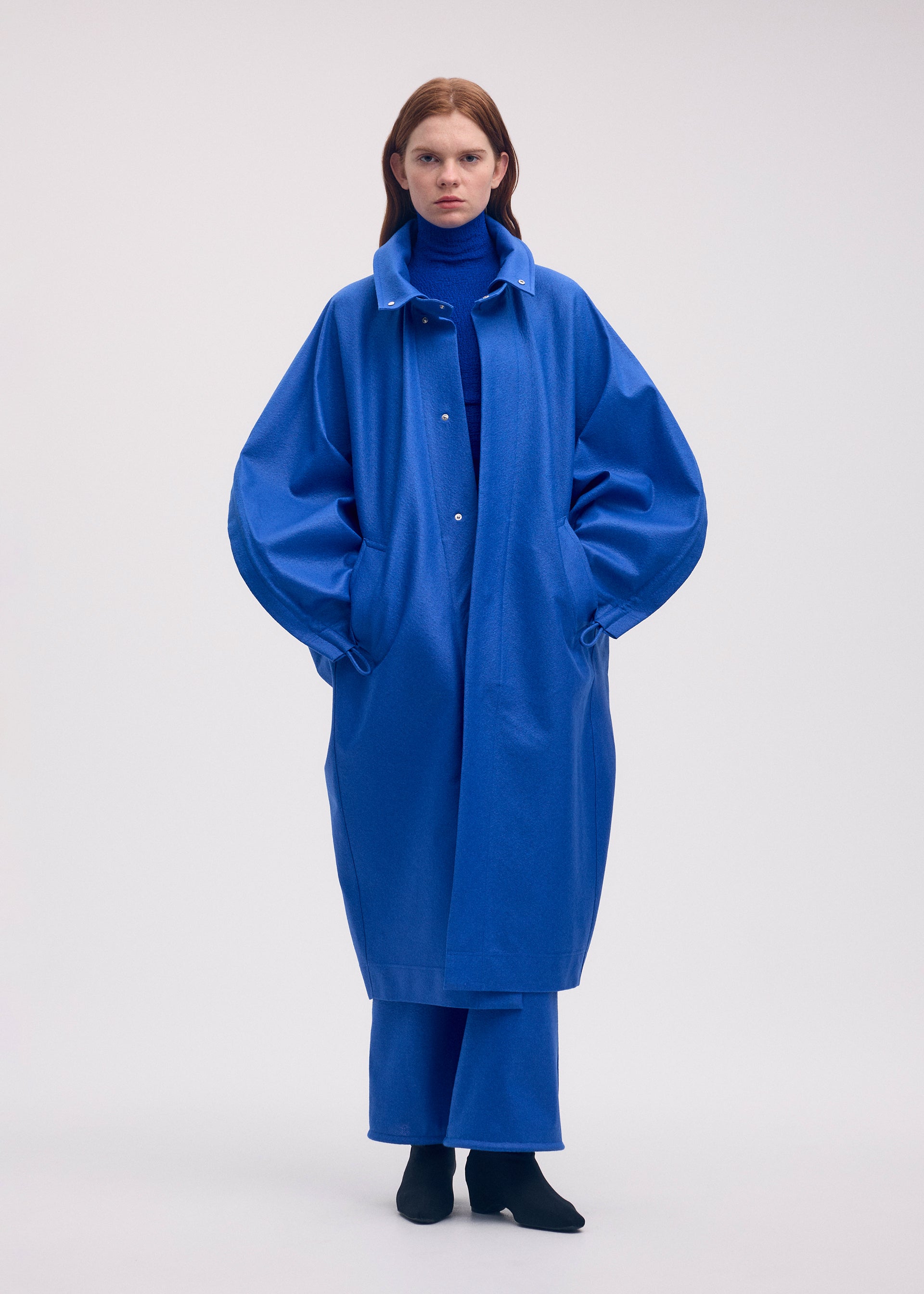 A model wears the ISSEY MIYAKE HANG OR CARRY coat.