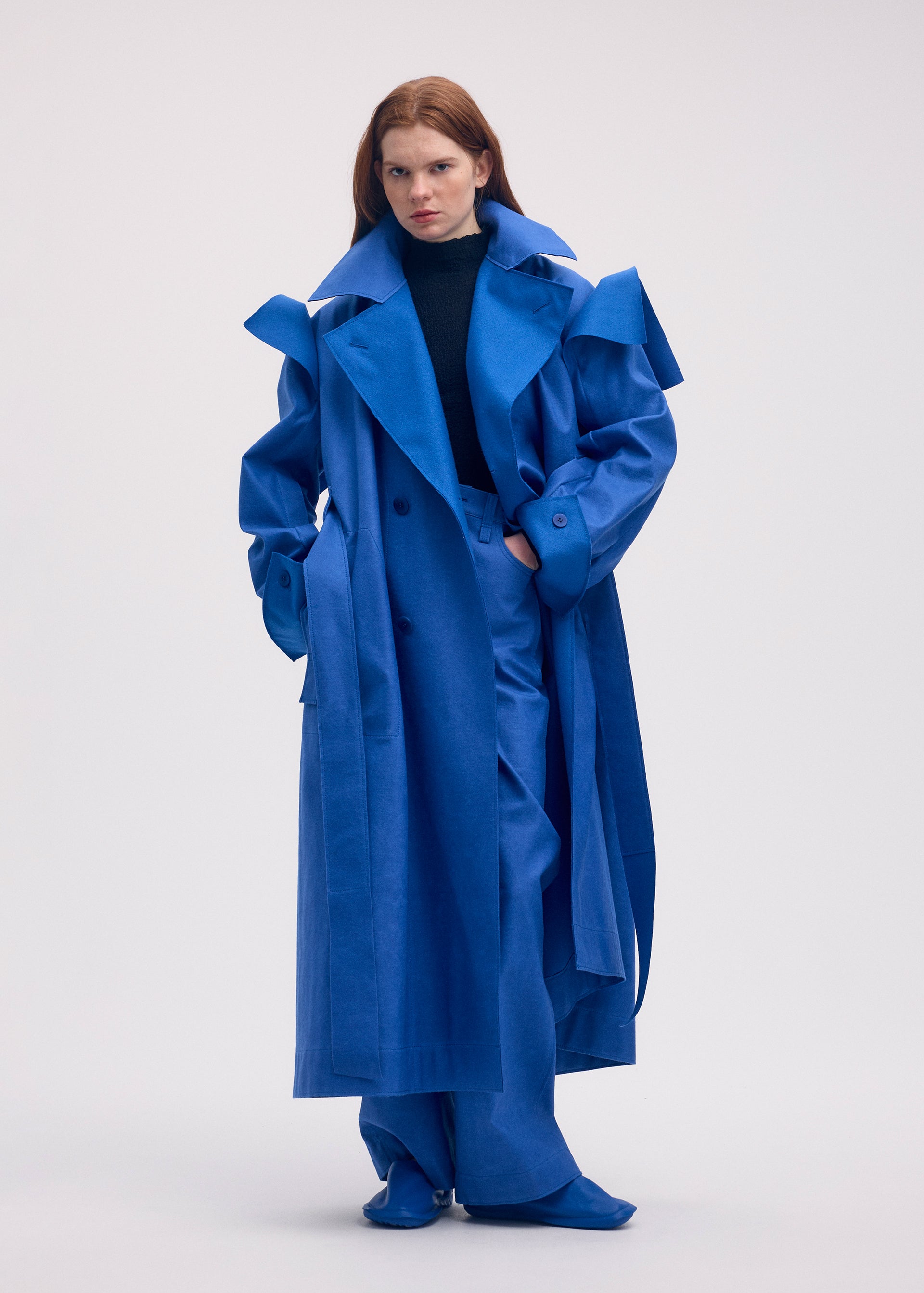 A model wears the ISSEY MIYAKE LEFT UNDONE coat.