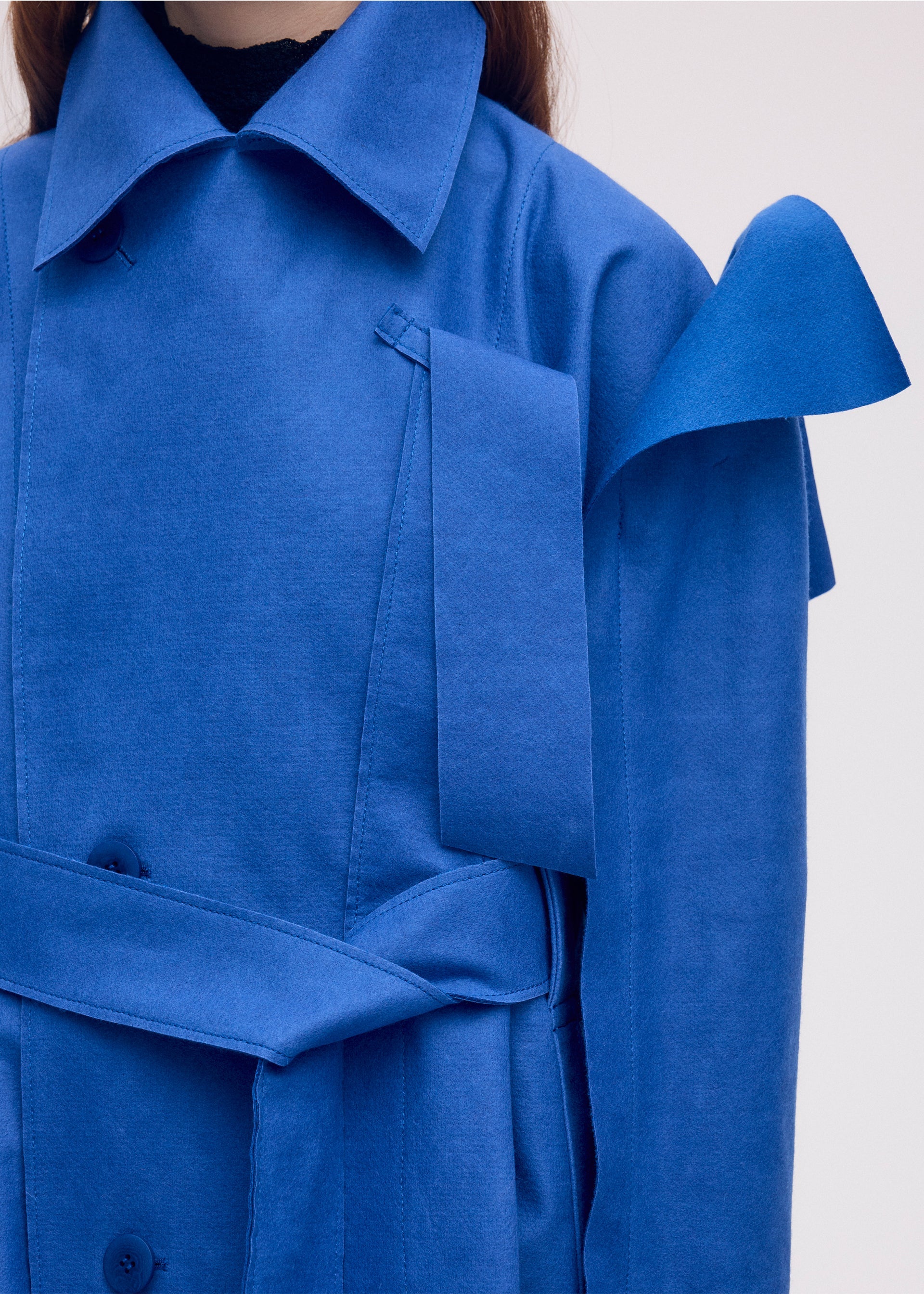 A model wears the ISSEY MIYAKE LEFT UNDONE coat.