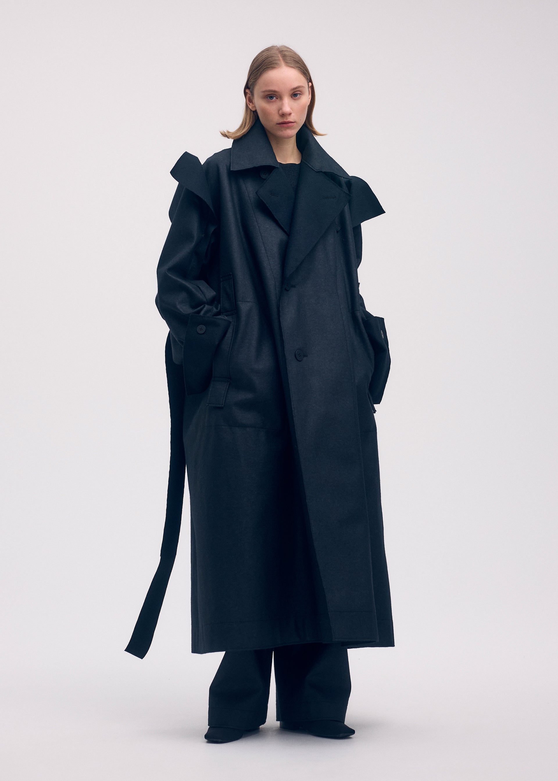 A model wears the ISSEY MIYAKE LEFT UNDONE coat.