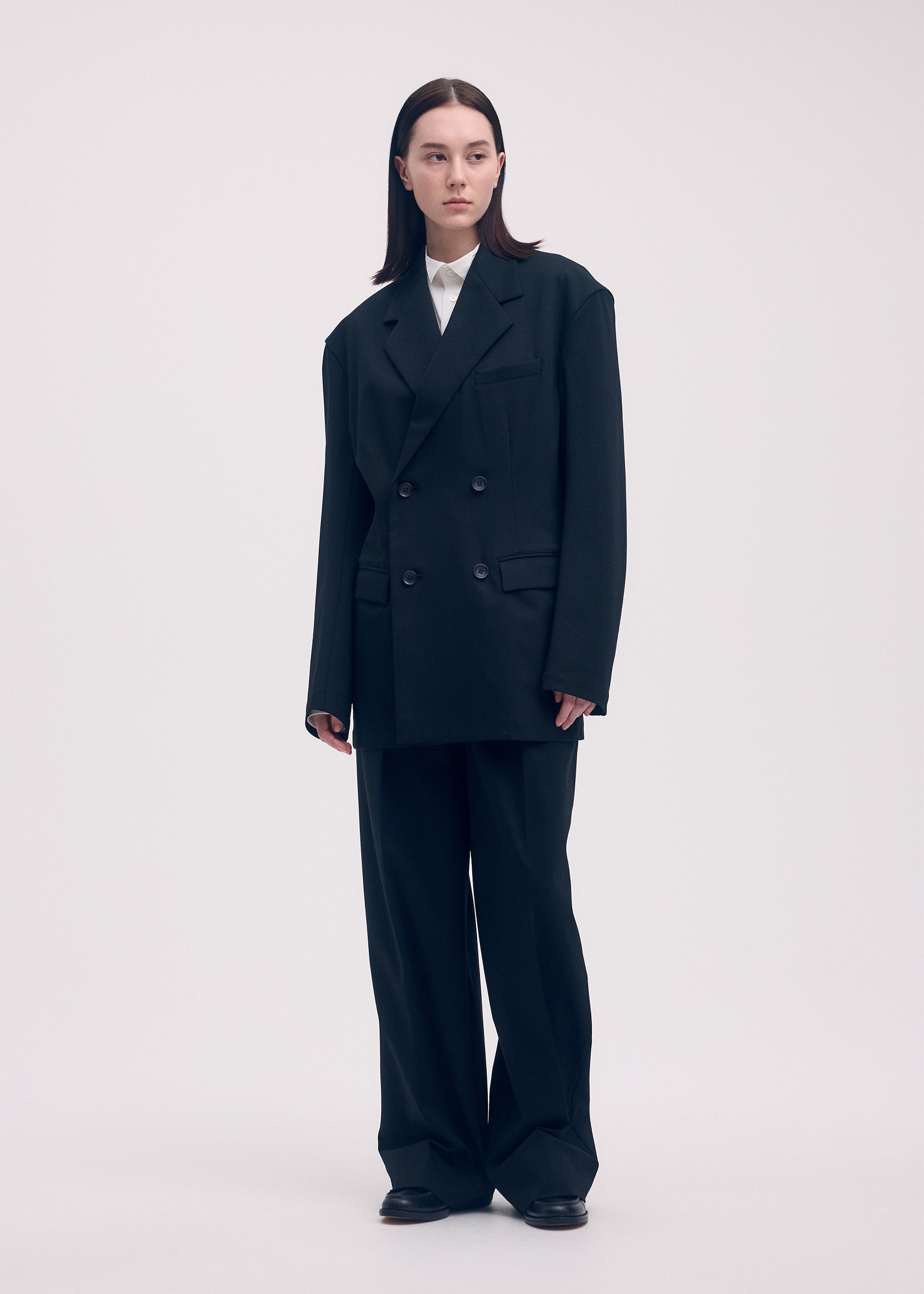 A model wears the ISSEY MIYAKE SIMPLE ENSEMBLE trousers.