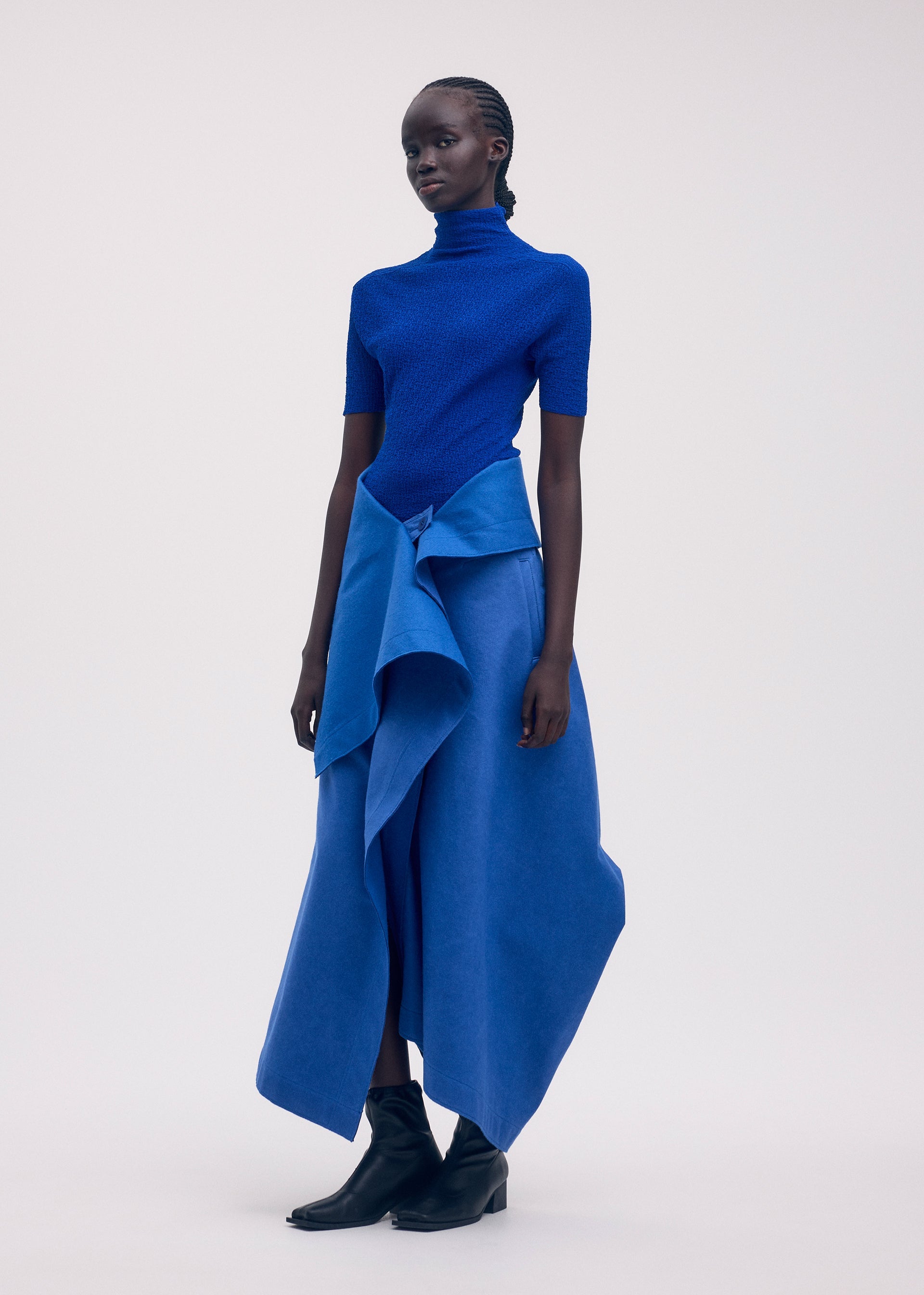 A model wears the ISSEY MIYAKE LEFT UNDONE trousers.
