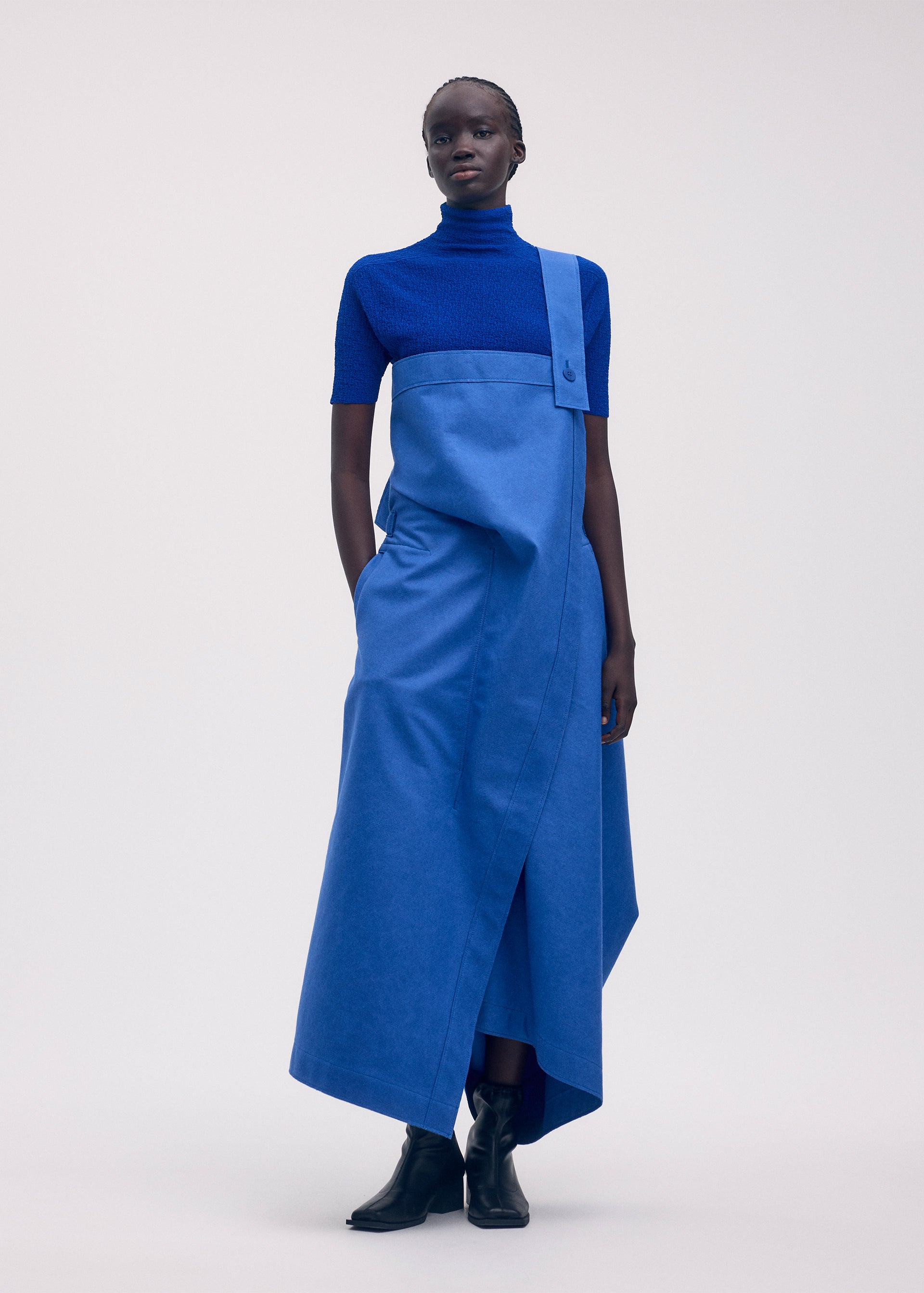 A model wears the ISSEY MIYAKE LEFT UNDONE trousers.