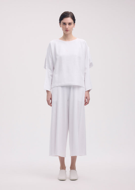 A model wears the ISSEY MIYAKE CAMPAGNE trousers.