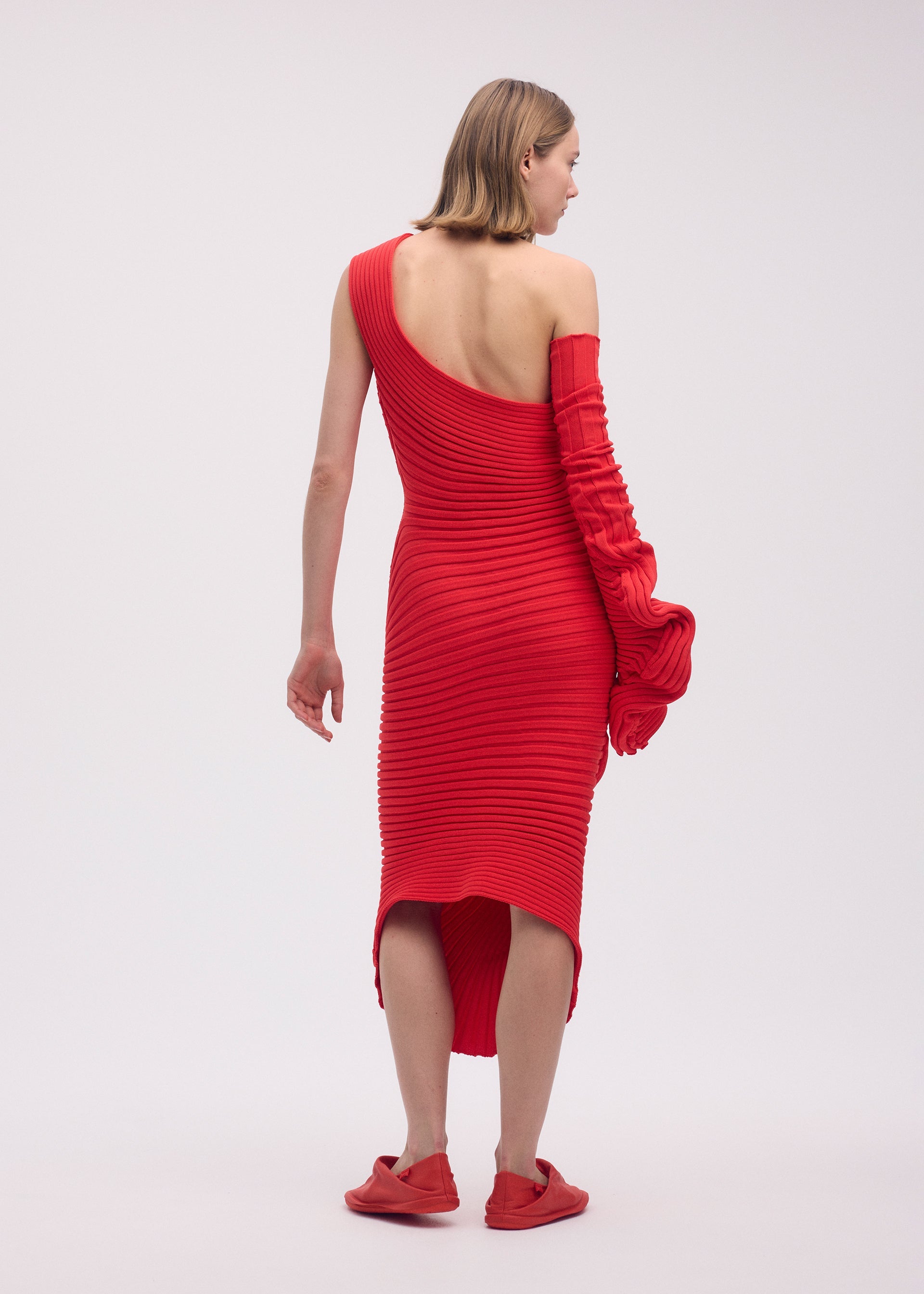 A model wears the ISSEY MIYAKE KNIT (AS IT IS) dress.