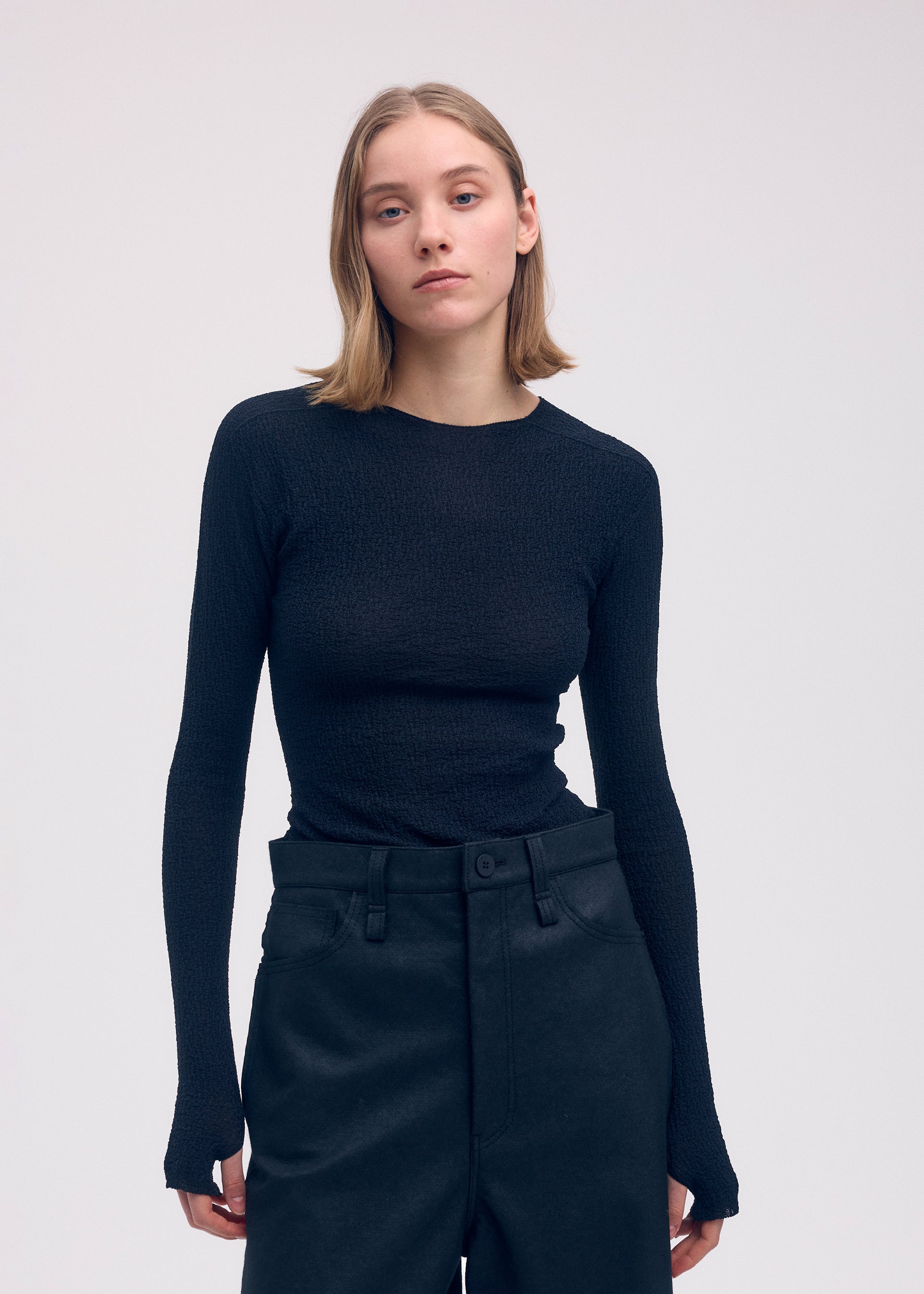 A model wears the ISSEY MIYAKE BODY KNIT top.