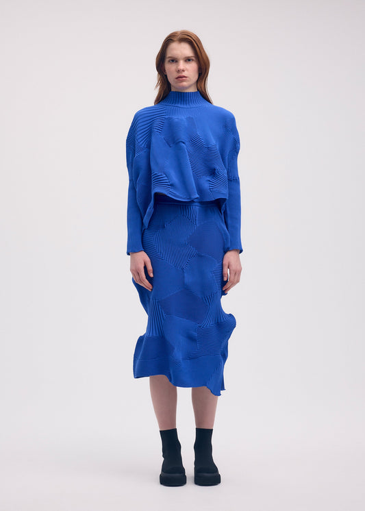 A model wears the ISSEY MIYAKE KONE KONE top.