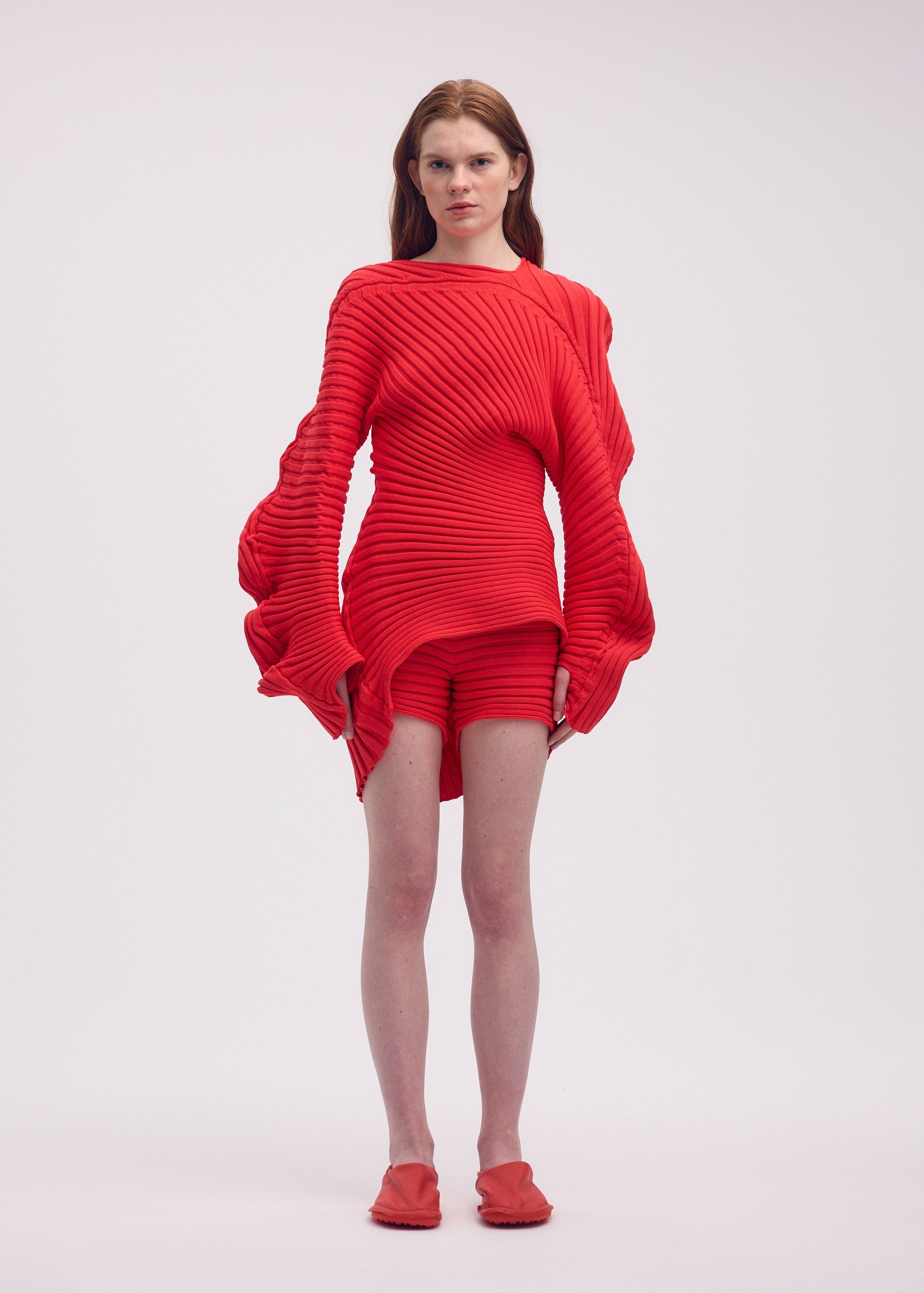 A model wears the ISSEY MIYAKE KNIT (AS IT IS) top.