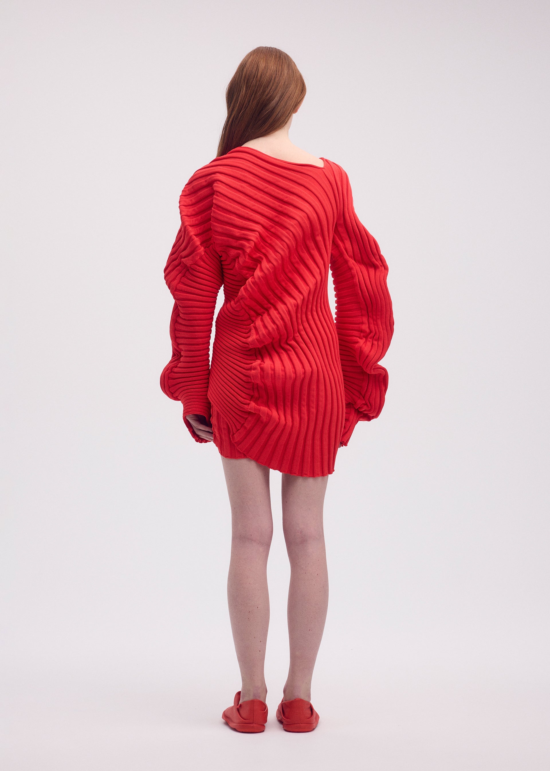 A model wears the ISSEY MIYAKE KNIT (AS IT IS) top.