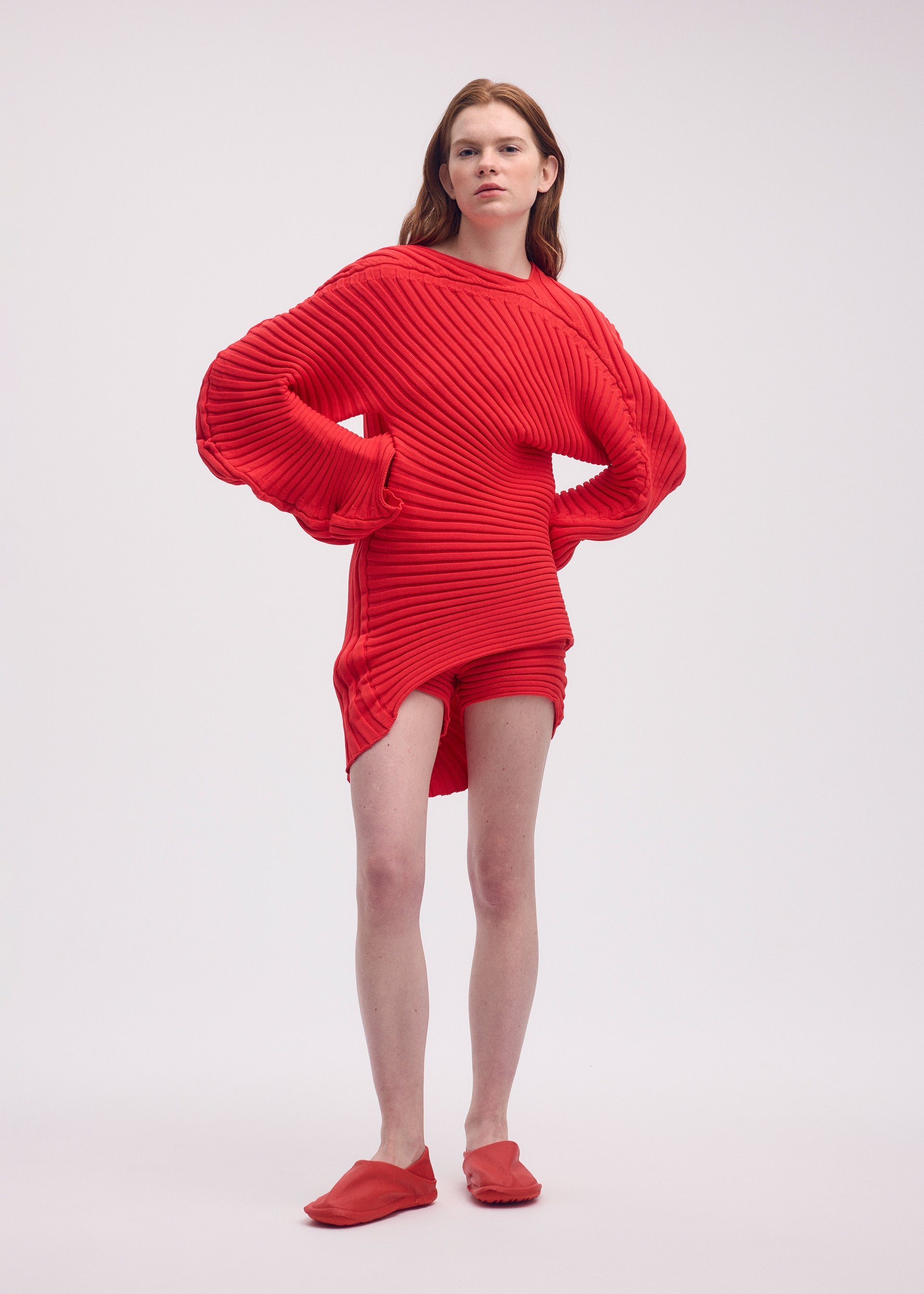 A model wears the ISSEY MIYAKE KNIT (AS IT IS) top.