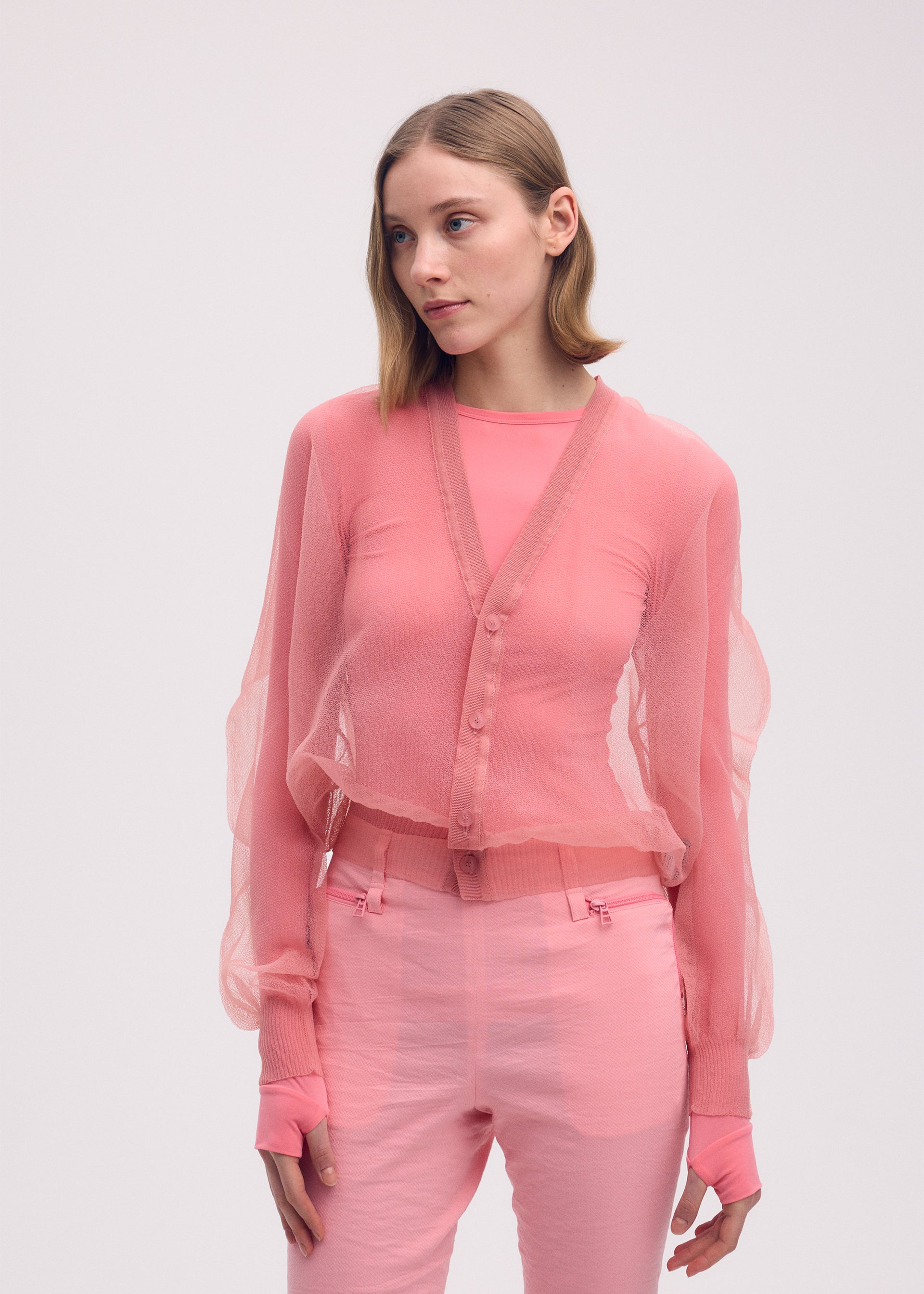 A model wears the ISSEY MIYAKE ENCASE cardigan.