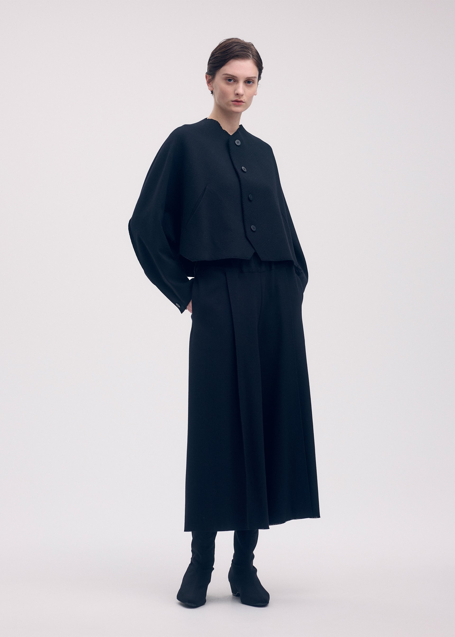 A model wears the ISSEY MIYAKE CAMPAGNE cardigan.