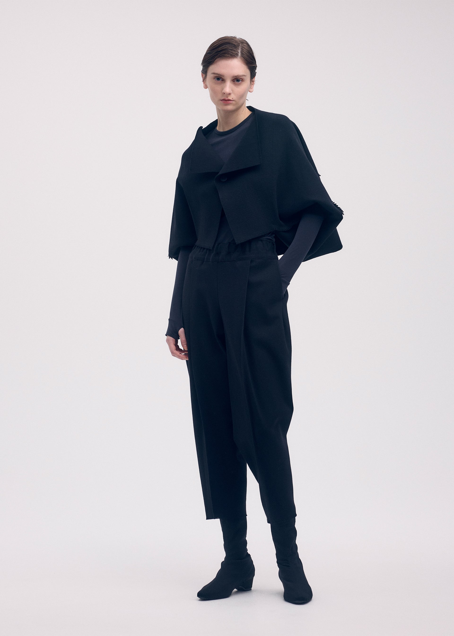 A model wears the ISSEY MIYAKE CAMPAGNE cardigan.