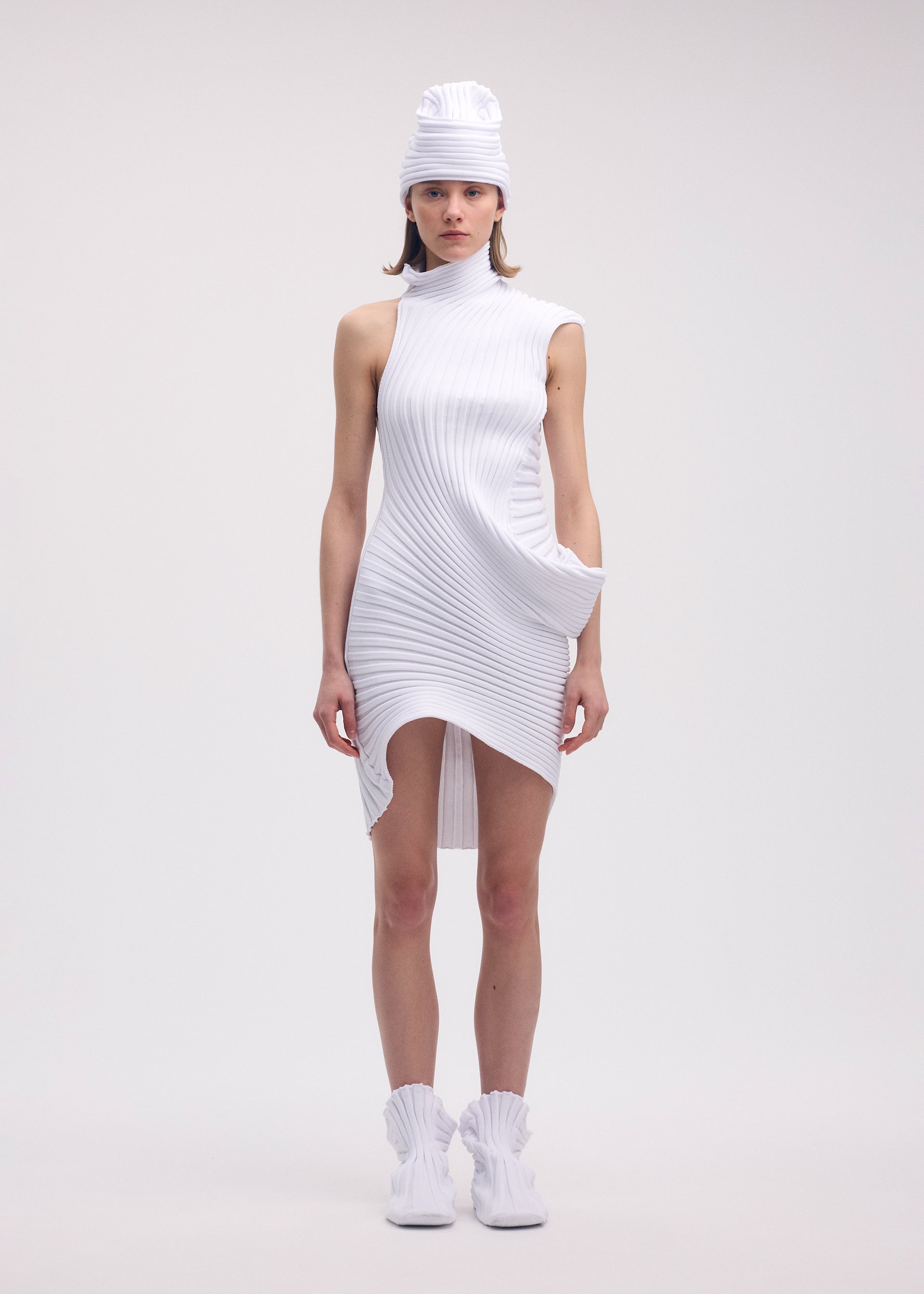 A model wears the ISSEY MIYAKE KNIT (AS IT IS) tunic.