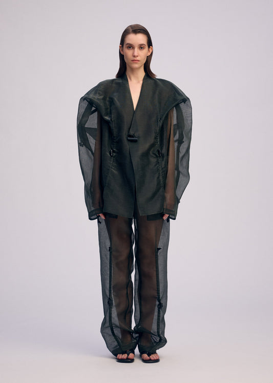 A model wears the ISSEY MIYAKE DRAW TO FORM jacket.