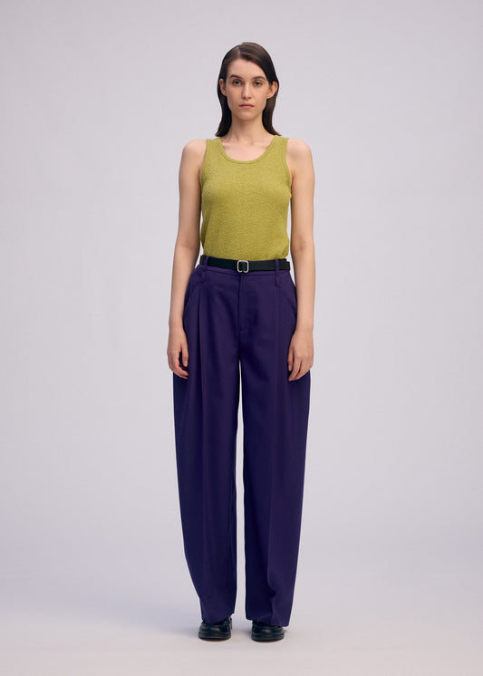 A model wears the ISSEY MIYAKE BELTED WOOL PANTS trousers.