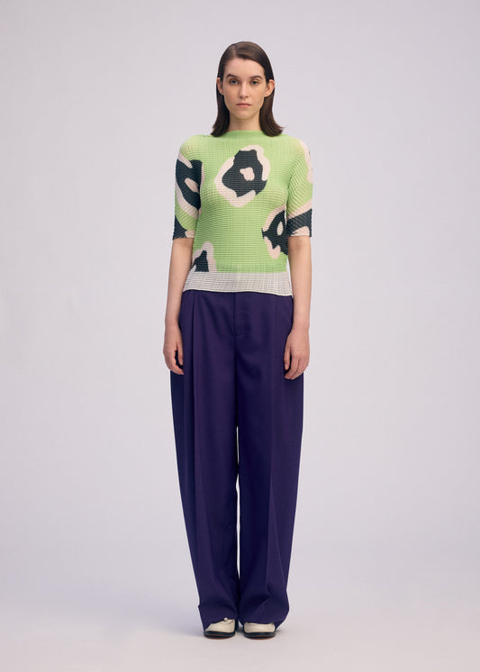 A model wears the ISSEY MIYAKE VERVE PLEATS TOP shirt.