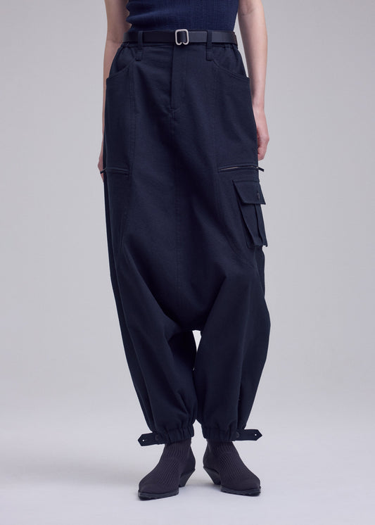 A model wears the ISSEY MIYAKE GRAINY PANTS grainy-pants-trousers-off-white.