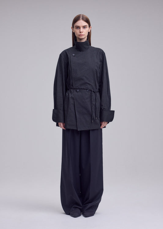 A model wears the ISSEY MIYAKE MONSIEUR SHIRT(DOBBY STRIPE) monsieur-shirt-dobby-stripe-bolo-tie-belt-shirt-white-hued.