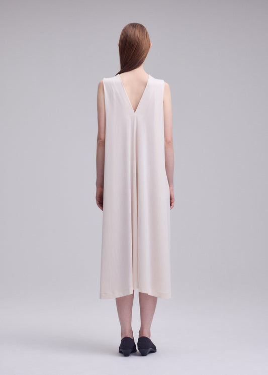 A model wears the ISSEY MIYAKE DRAPE JERSEY-68 drape-jersey-68-dress-off-white.