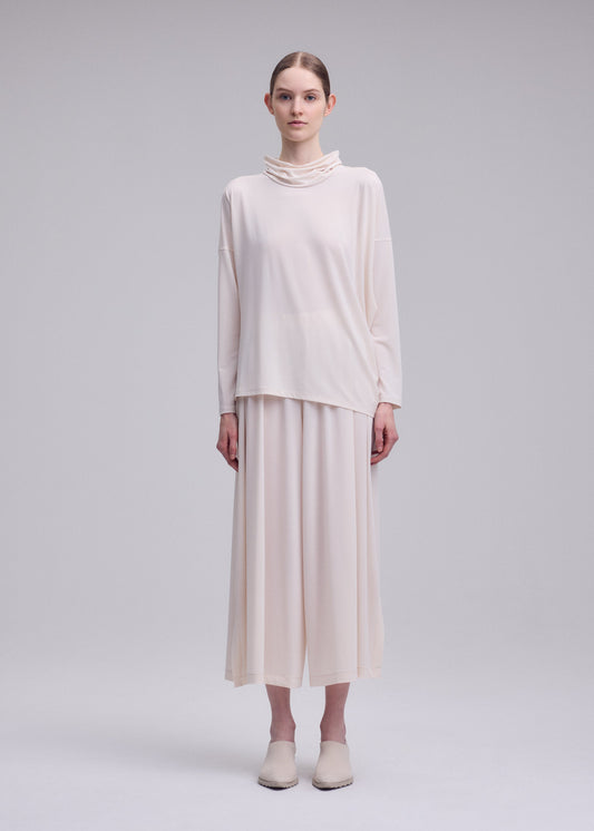 A model wears the ISSEY MIYAKE DRAPE JERSEY-68 shirt.
