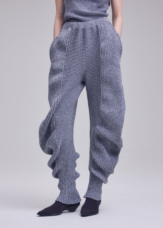 A model wears the ISSEY MIYAKE FOUND STONE found-stone-trousers-off-white.