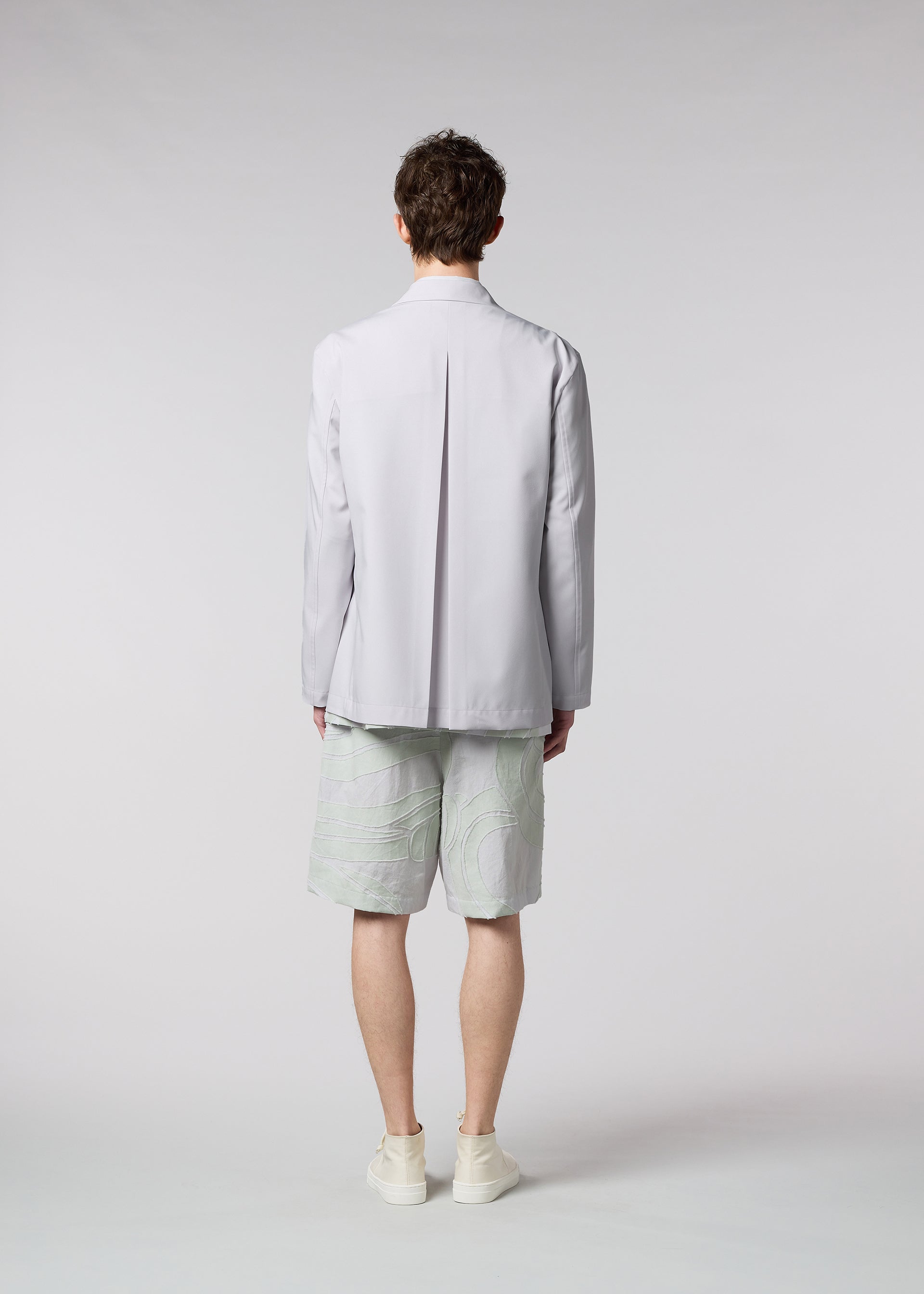 A model wears the ISSEY MIYAKE MEN WINGS jacket.