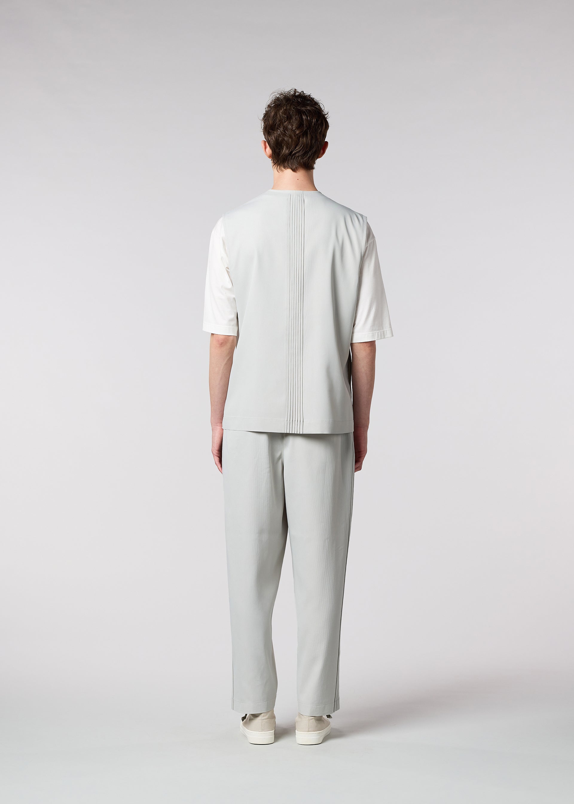 A model wears the IM MEN AIR PLEATS trousers.