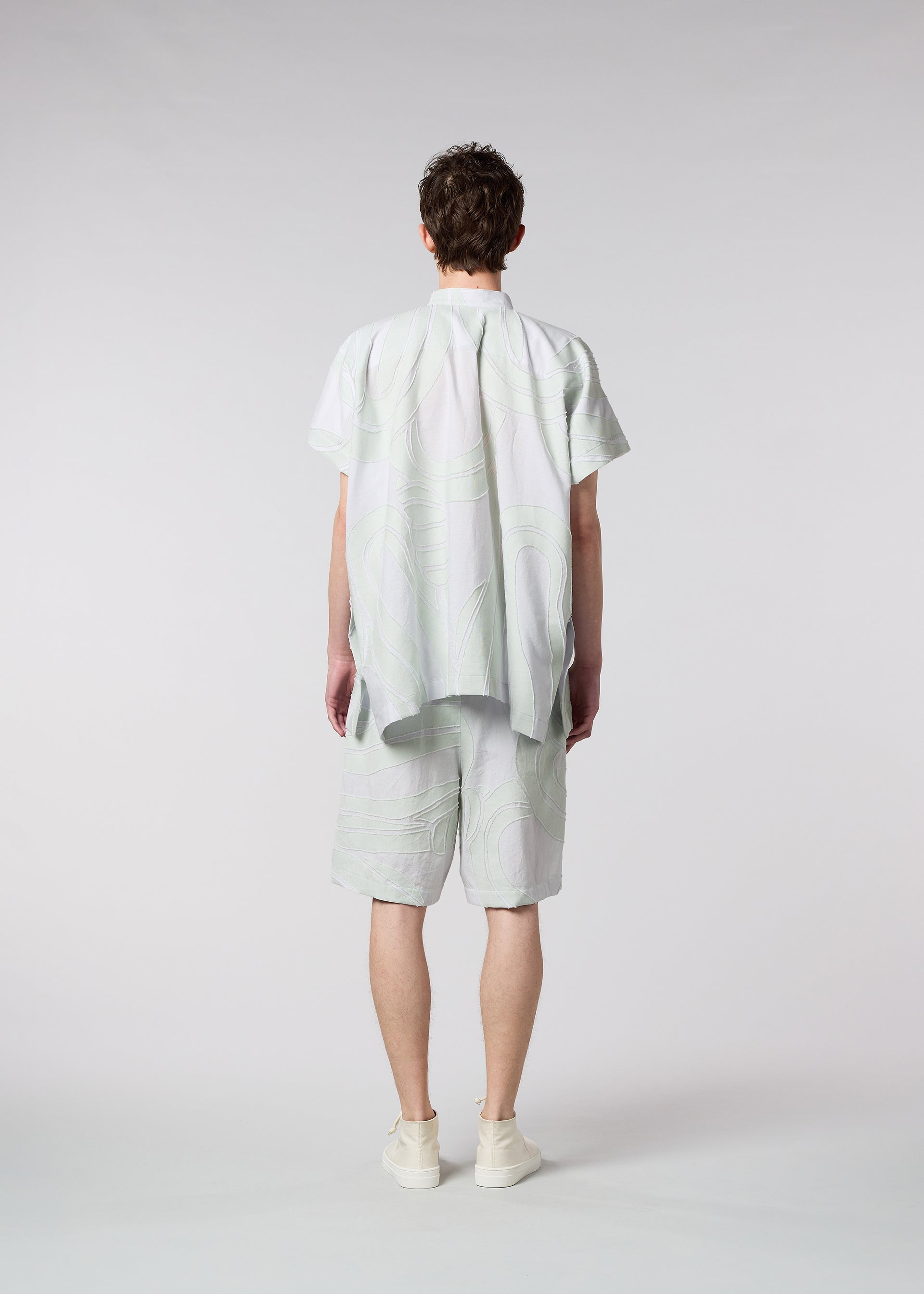 A model wears the ISSEY MIYAKE MEN SCENES trousers.