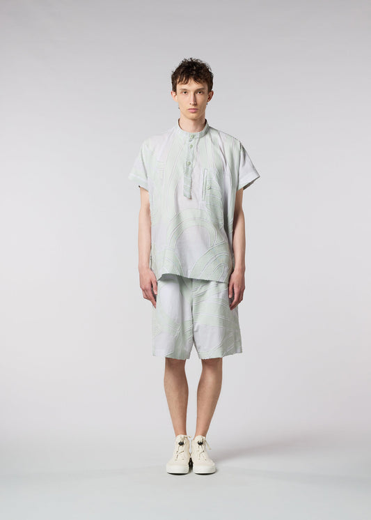 A model wears the ISSEY MIYAKE MEN SCENES shirt.