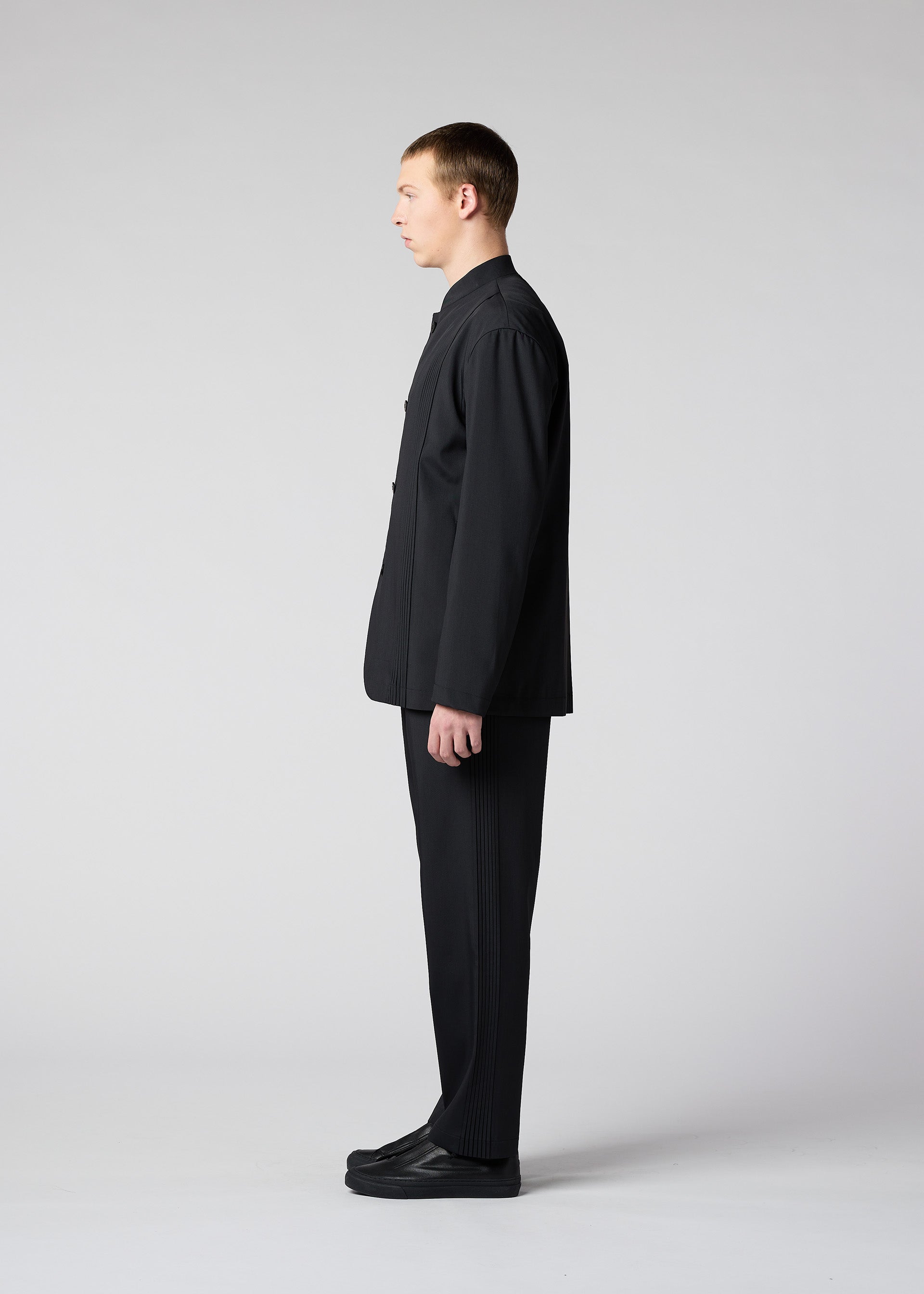 A model wears the IM MEN AIR PLEATS trousers.