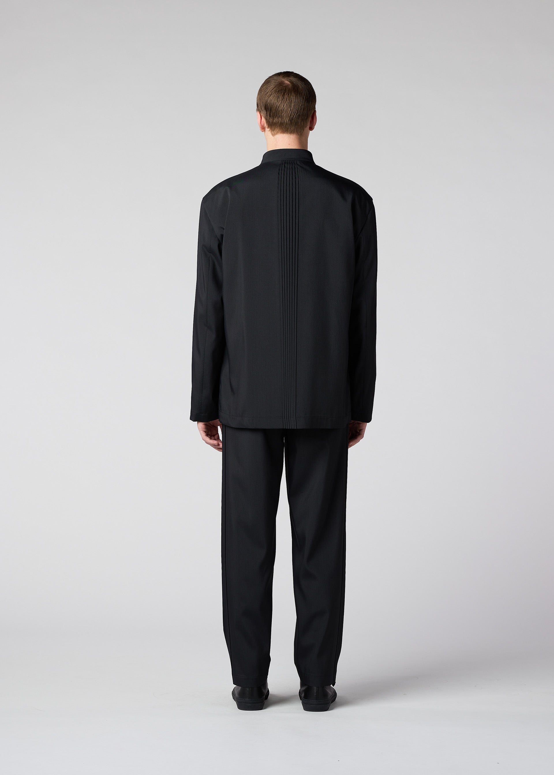 A model wears the IM MEN AIR PLEATS trousers.