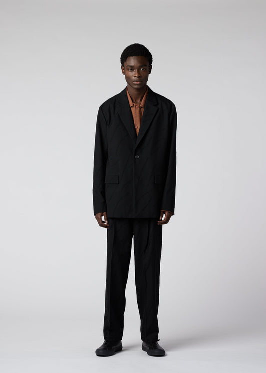 A model wears the IM MEN FLY WOOL trousers.